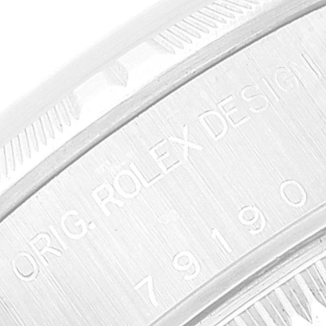This is a close-up of the case side of a Rolex Date 79190 Women's Stainless Steel Pink Dial 79190 Women's Stainless Steel Pink Dial model, showing the engraving and fluted bezel.