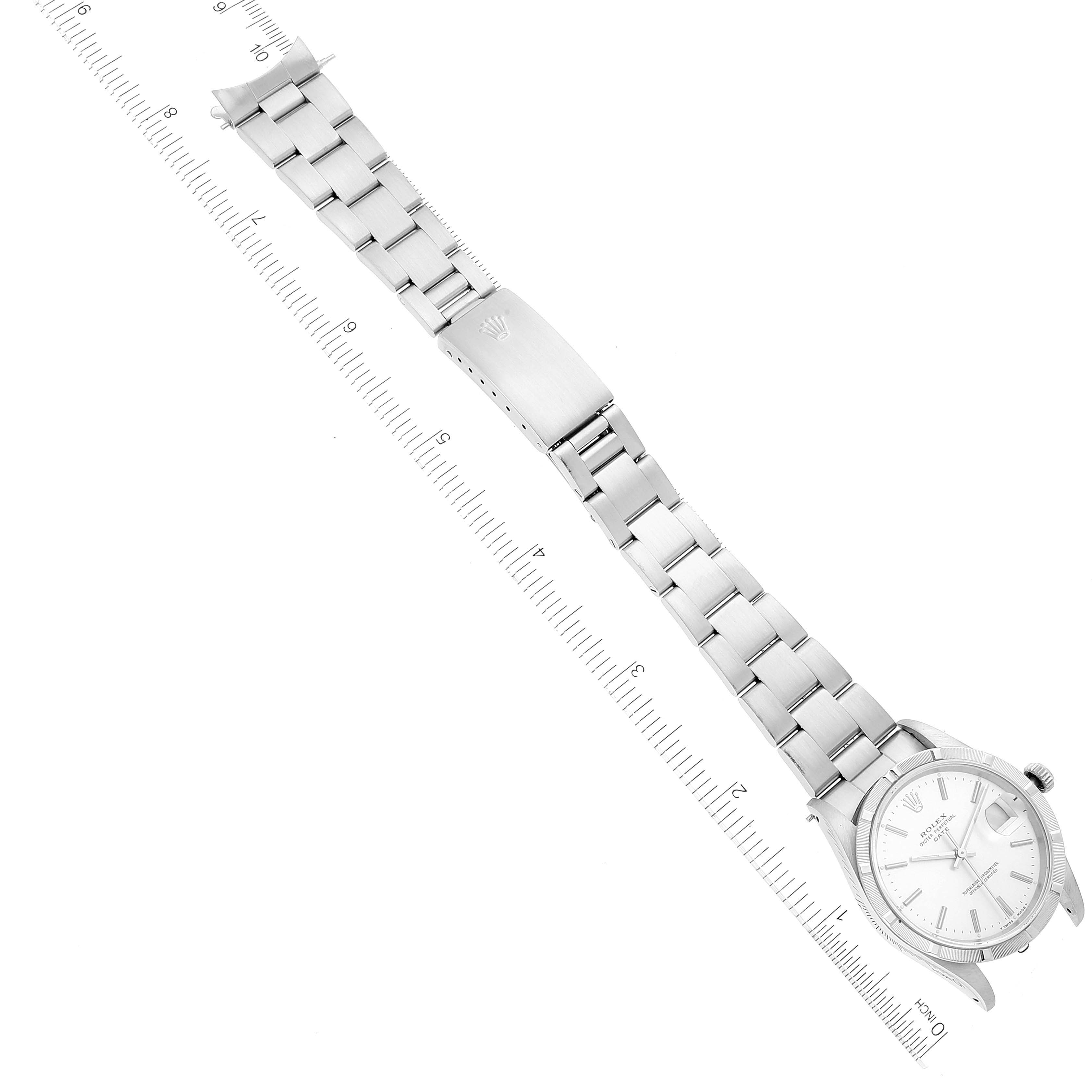This image shows a top-down view of a Rolex Date 15210 Men's Stainless Steel Silver Dial 15210 Men's Stainless Steel Silver Dial model watch, including its dial, case, and full bracelet with a ruler for scale.
