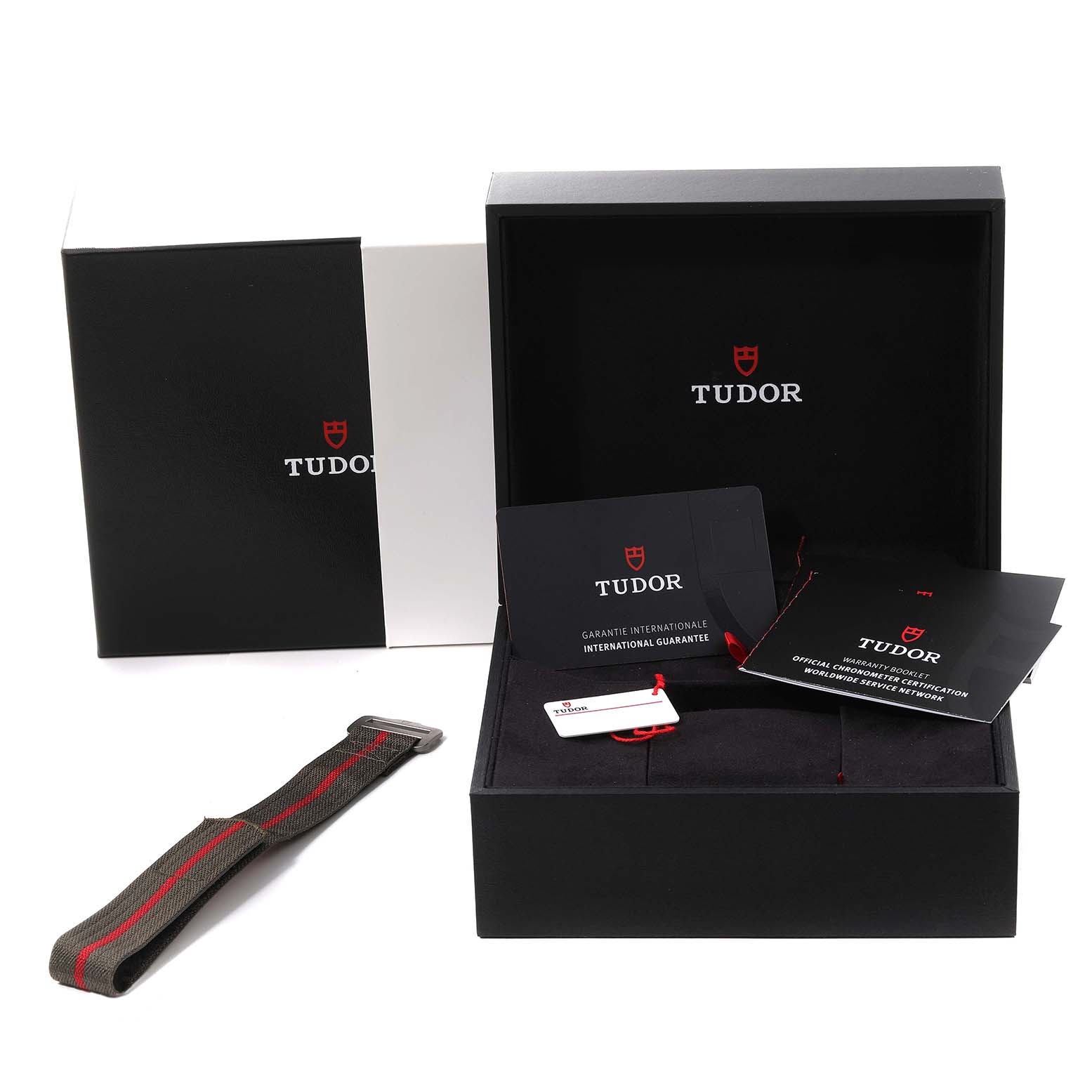 The image shows the Tudor Pelagos M25717N-0001 Men's Titanium Black Dial M25717N-0001 Men's Titanium Black Dial watch packaging, including a box, international guarantee cards, and an additional strap.