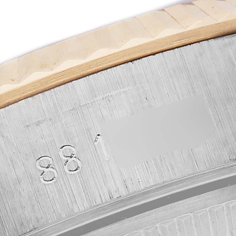 This close-up shows part of the engraved bezel of a Rolex Date 69173 Women's Steel and Gold (two tone) White Dial 69173 Women's Steel and Gold (two tone) White Dial model.