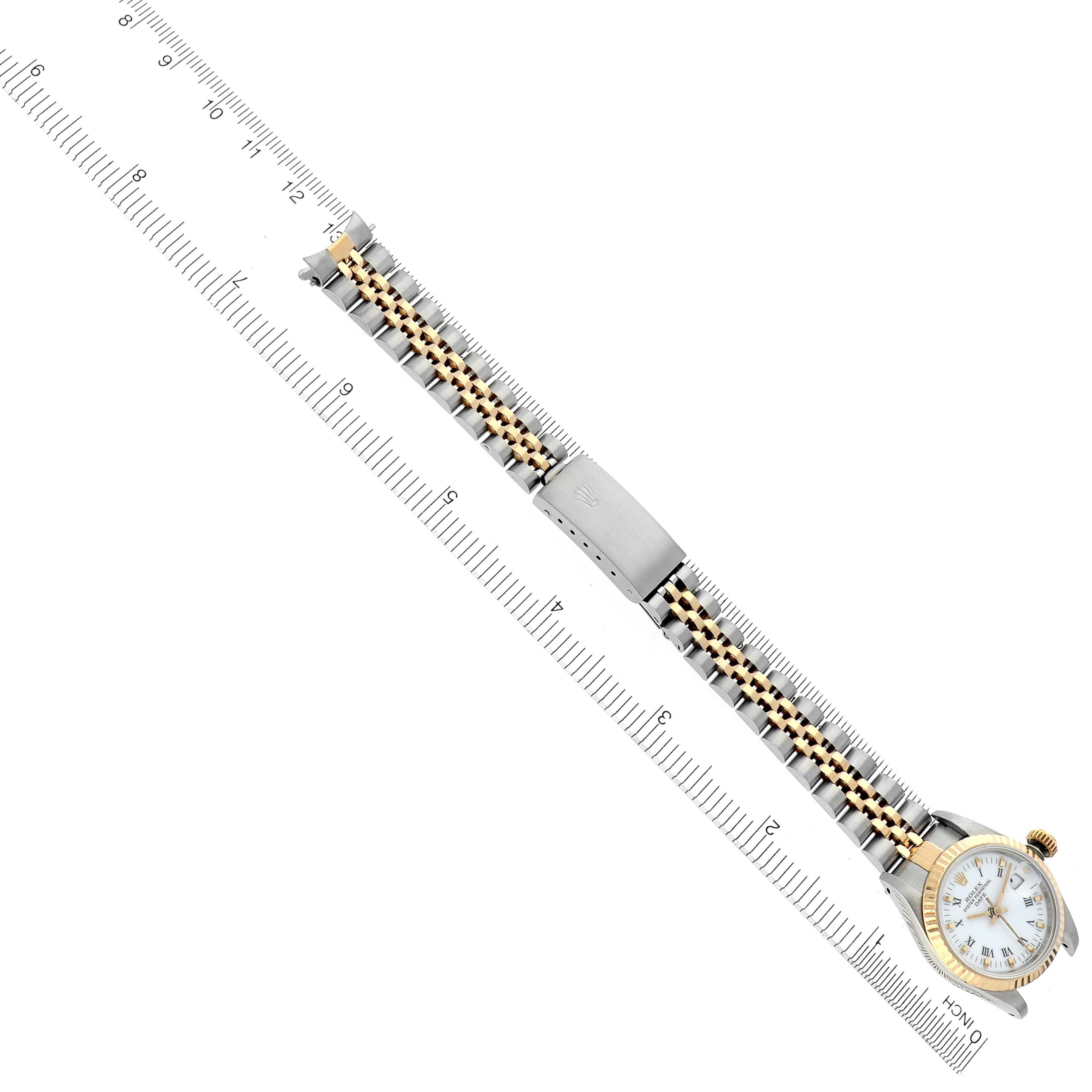 The Rolex Date 69173 Women's Steel and Gold (two tone) White Dial 69173 Women's Steel and Gold (two tone) White Dial watch is shown from a top view, displaying the dial, bezel, bracelet, and clasp, aligned with a ruler for scale.