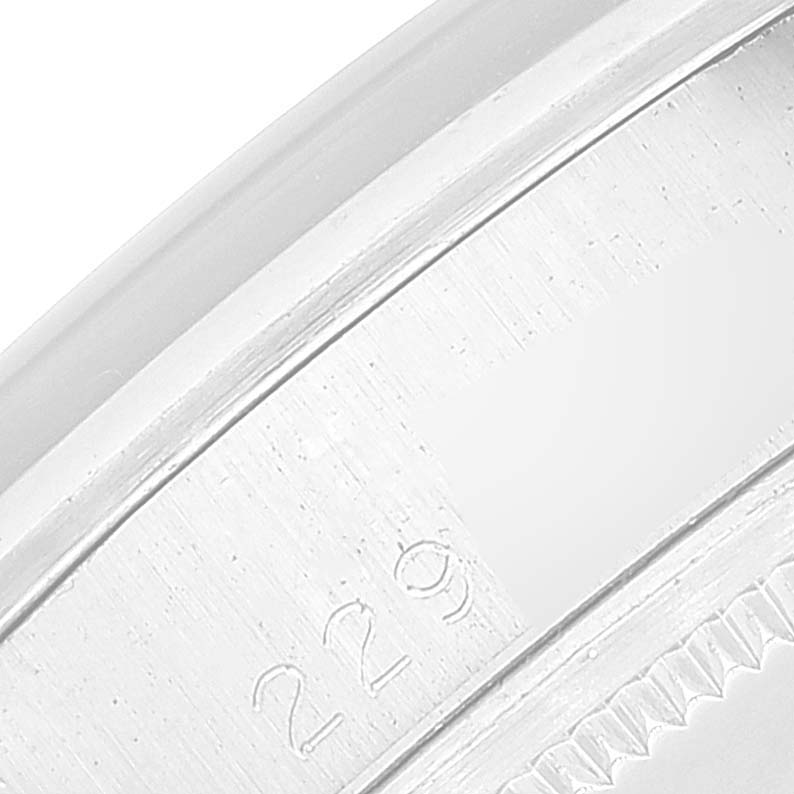 This is a close-up of the case side and bezel of the Rolex Date 1500 Men's Stainless Steel Silver Dial 1500 Men's Stainless Steel Silver Dial model, showing engraved details.