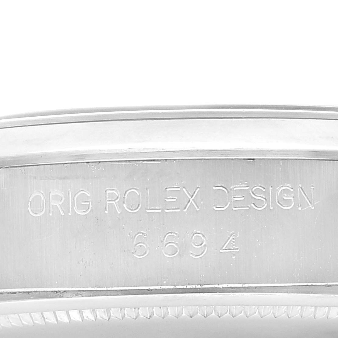 The image shows a close-up of the case side of a Rolex Date 6694 Men's Stainless Steel Silver Dial 6694 Men's Stainless Steel Silver Dial model with the engraving "ORIG ROLEX DESIGN 6694."