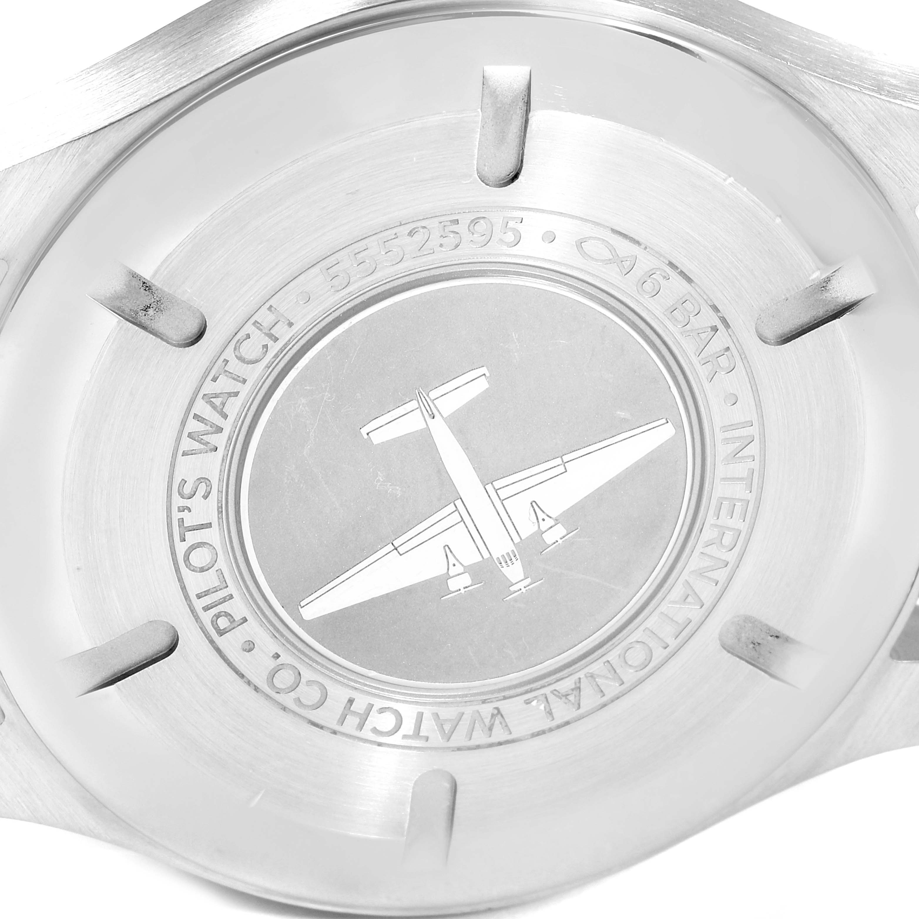 This image shows the back case of an IWC Pilot IW327001 Men's Stainless Steel Black Dial IW327001 Men's Stainless Steel Black Dial model watch, featuring an engraved airplane and inscriptions.