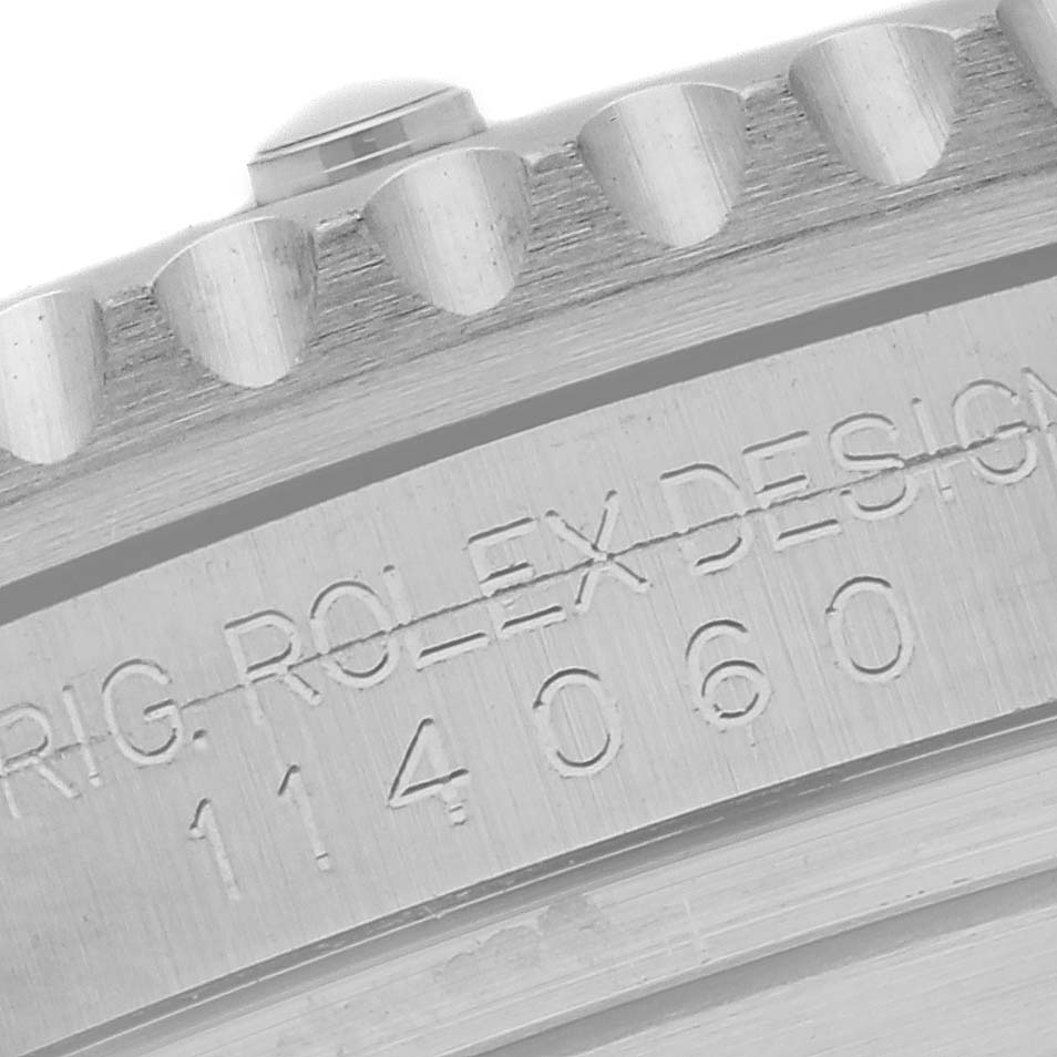 The image shows a close-up of the engraved case and bezel edge of a Rolex Submariner 114060 Men's Stainless Steel Black Dial 114060 Men's Stainless Steel Black Dial.