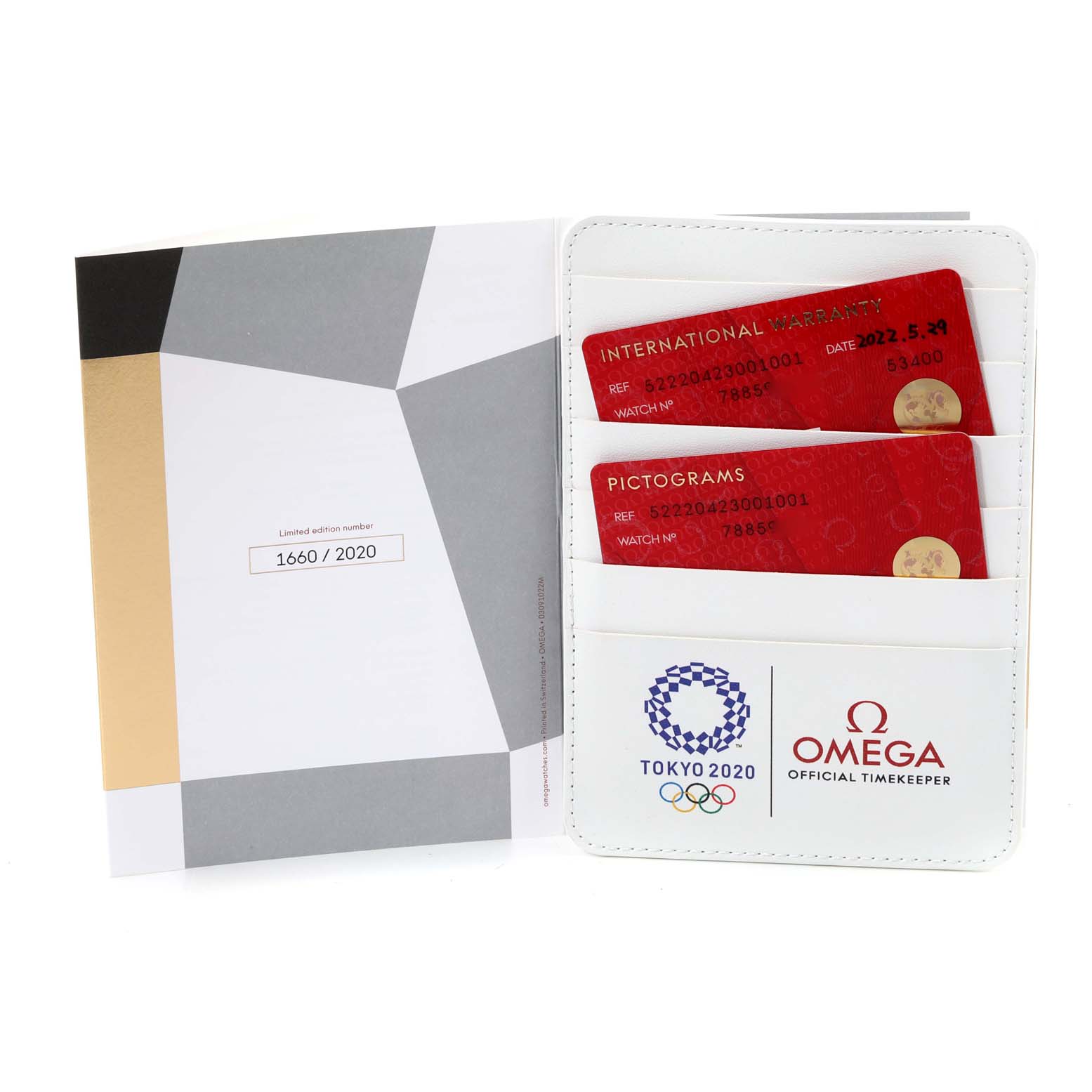 The image shows warranty and pictogram cards, and a certificate booklet for the Omega Speedmaster 522.20.42.30.01.001 Men's Steel and Gold (two tone) Black Dial 522.20.42.30.01.001 Men's Steel and Gold (two tone) Black Dial Tokyo 2020 limited edition.