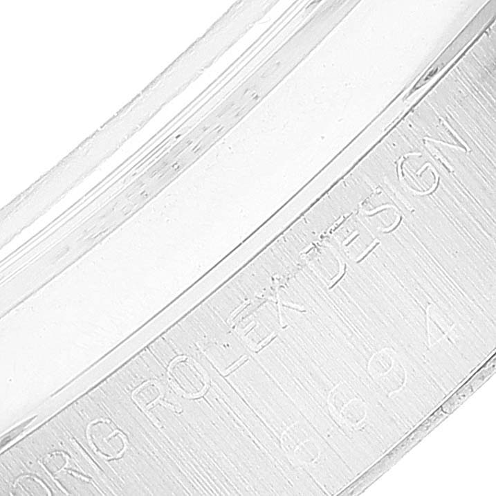 The image shows an engraved inner bezel of a Rolex Date 6694 Men's Stainless Steel Silver Dial 6694 Men's Stainless Steel Silver Dial model watch.