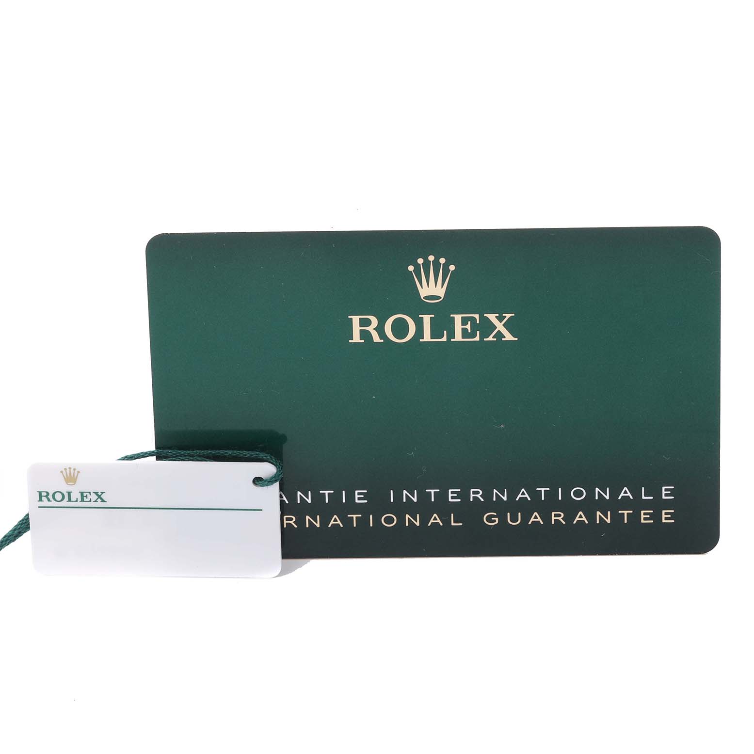The image shows a green Rolex international guarantee card and a white Rolex tag for the GMT-Master model.