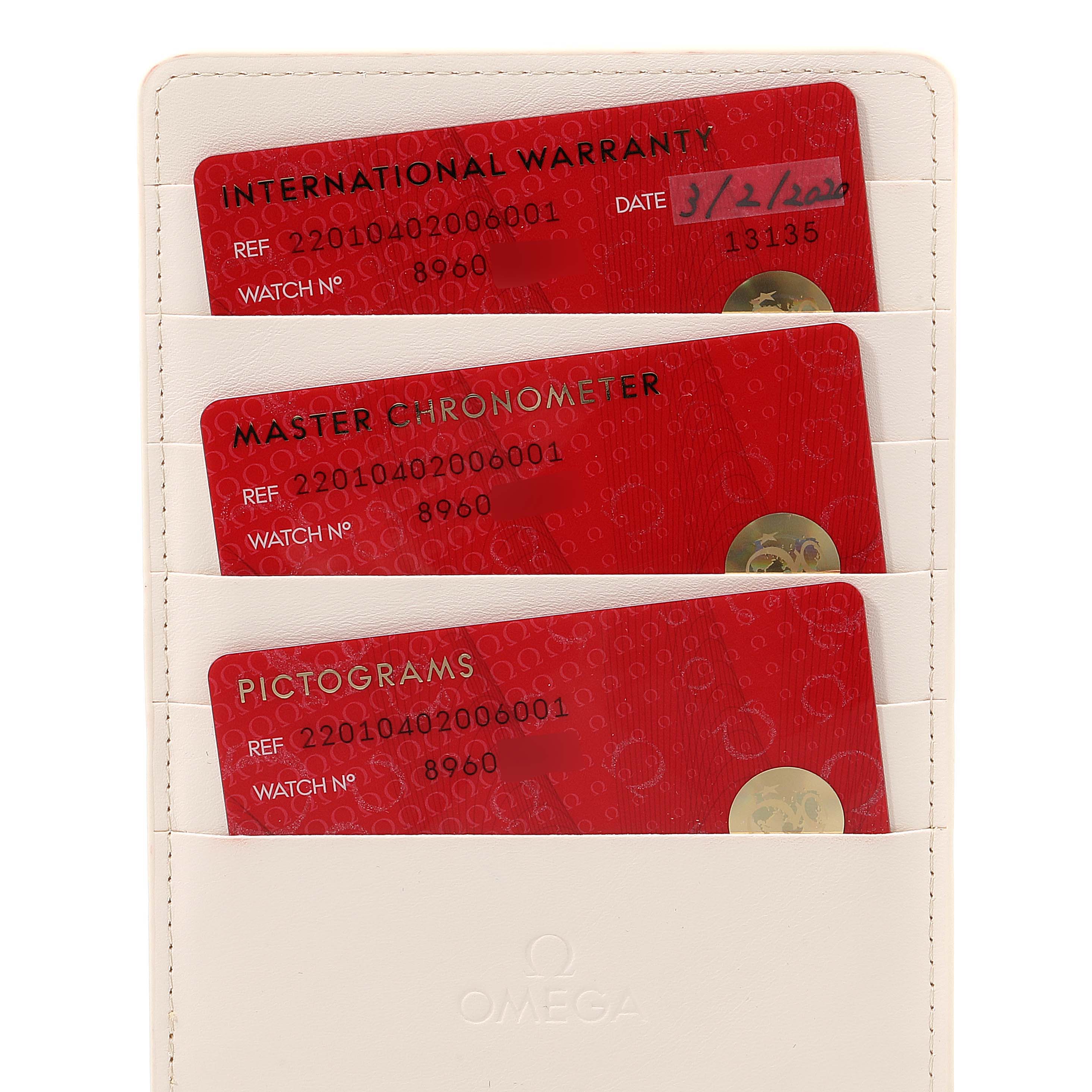 The image shows international warranty, master chronometer, and pictograms cards of an Omega Seamaster 220.10.40.20.06.001 Men's Stainless Steel Grey Dial 220.10.40.20.06.001 Men's Stainless Steel Grey Dial watch in a white holder.