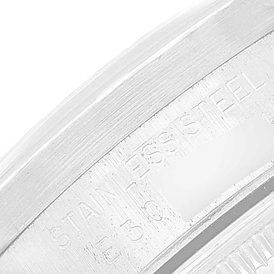 The image shows a close-up view of the engraved edge of a stainless steel Rolex Date 15210 Men's Stainless Steel Silver Dial 15210 Men's Stainless Steel Silver Dial model watch.