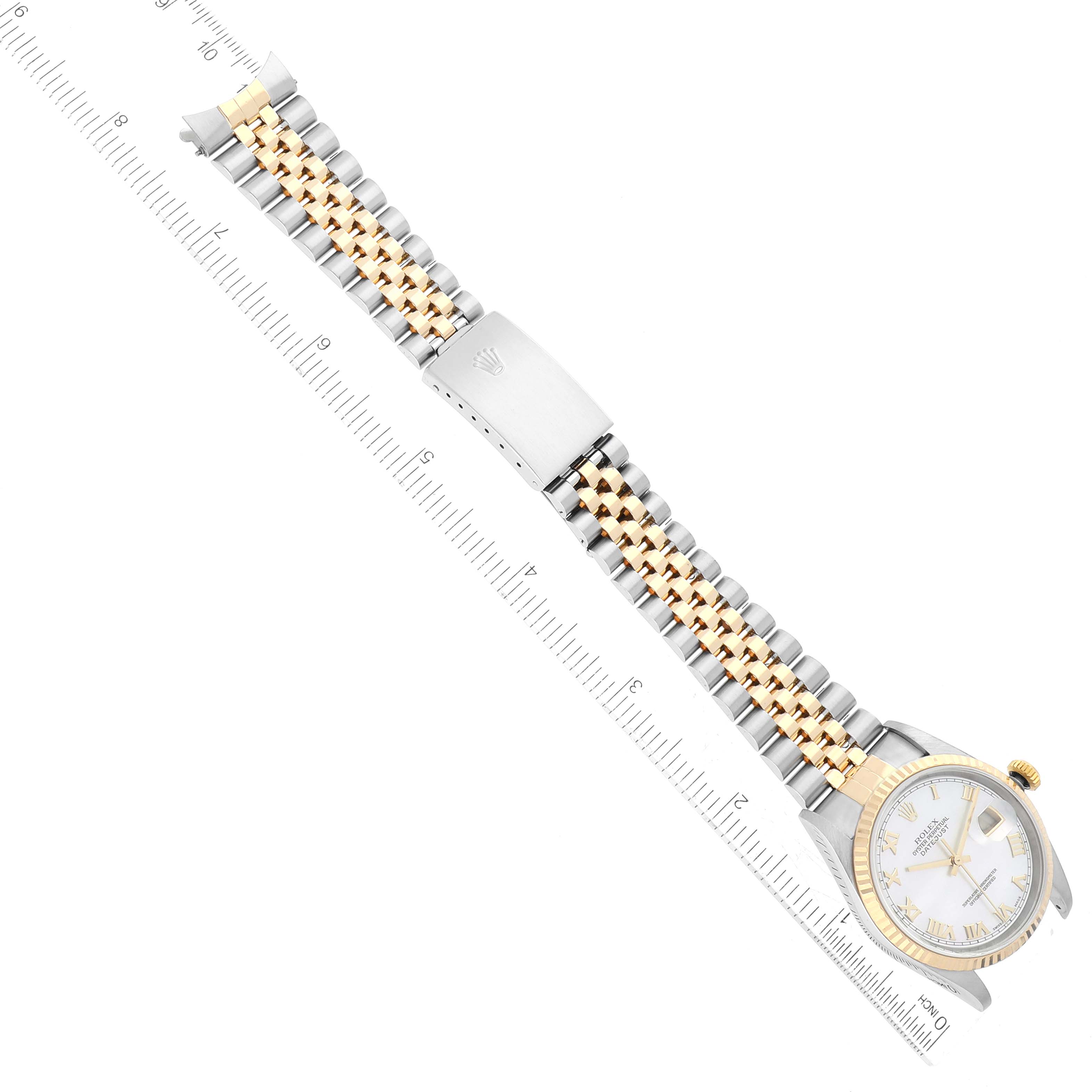 The Rolex Datejust 16233 Men's Steel and Gold (two tone) Mother of Pearl Dial 16233 Men's Steel and Gold (two tone) Mother of Pearl Dial watch is shown from a top-down angle, displaying its face and two-tone bracelet alongside a ruler for scale.