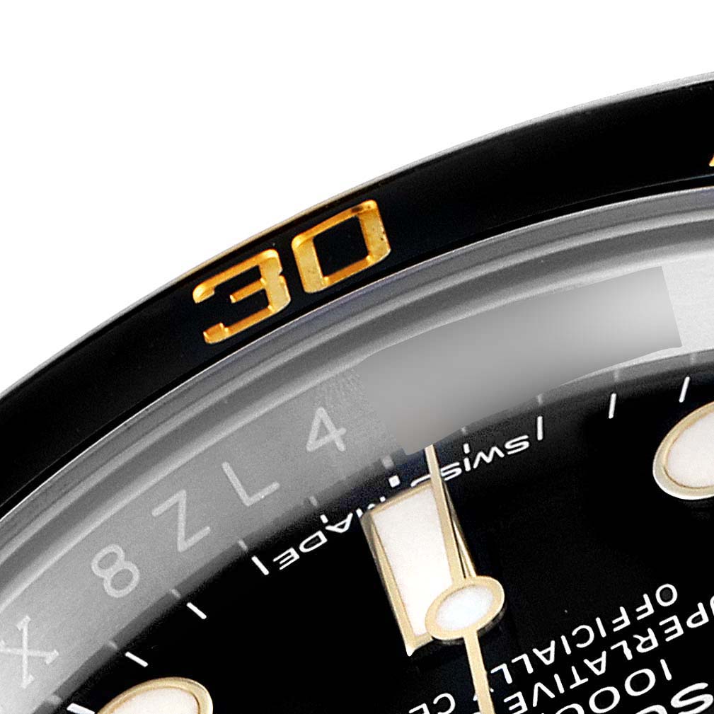 This close-up shows the bezel and part of the dial of the Rolex Submariner 116613 Men's Steel and Gold (two tone) Black Dial 116613 Men's Steel and Gold (two tone) Black Dial watch.