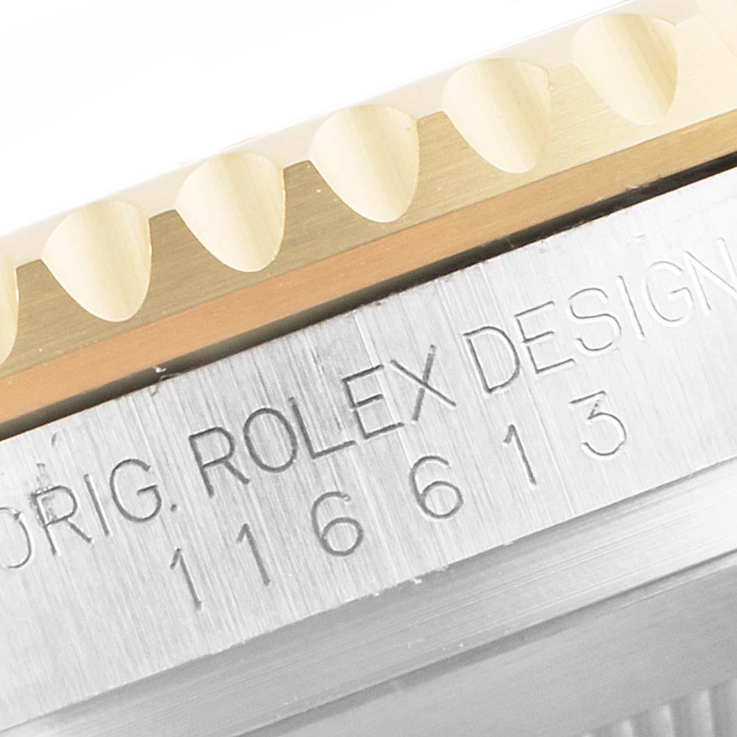 This image shows a close-up of the bezel and engraved side of the case of a Rolex Submariner 116613 Men's Steel and Gold (two tone) Black Dial 116613 Men's Steel and Gold (two tone) Black Dial watch model 116613.