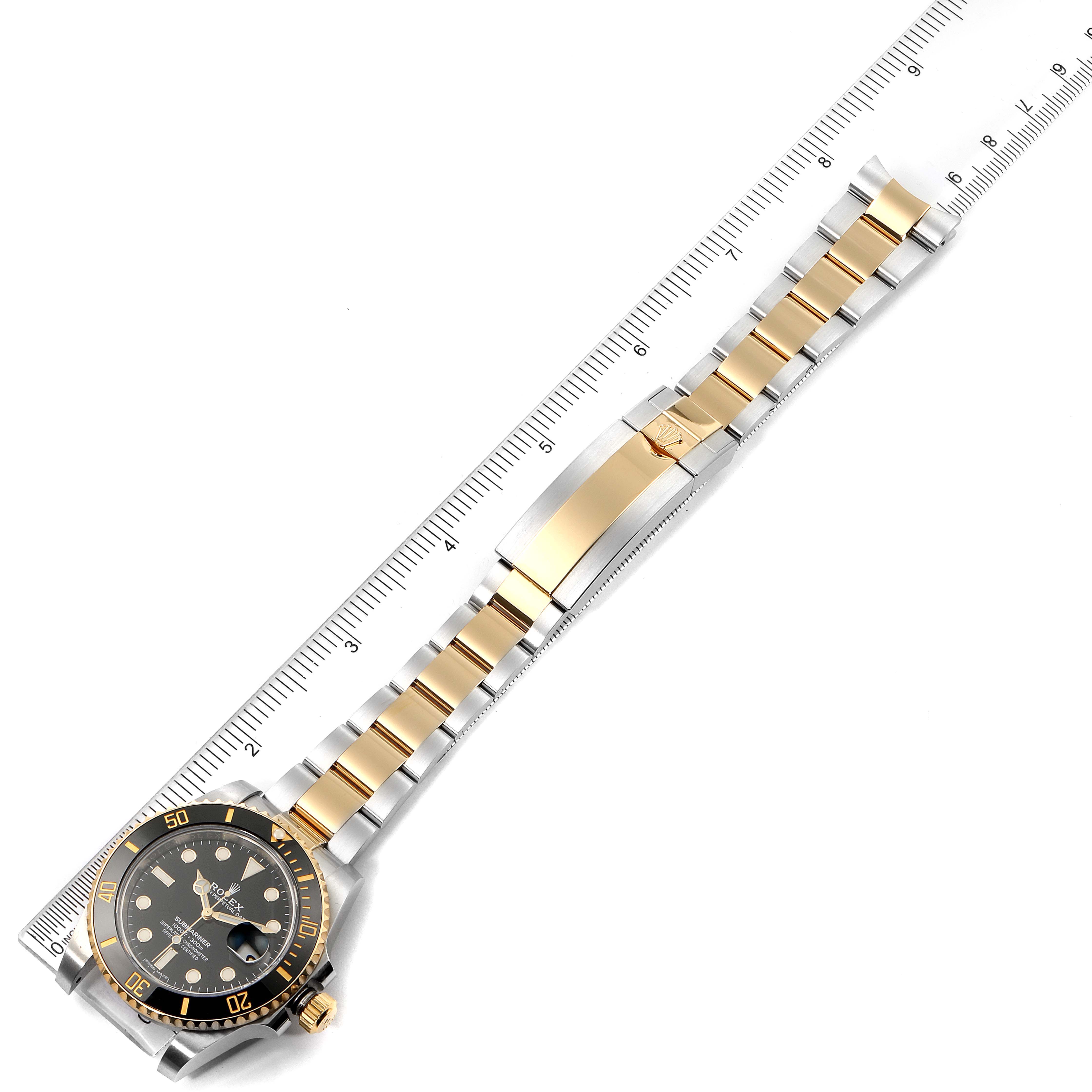The Rolex Submariner 116613 Men's Steel and Gold (two tone) Black Dial 116613 Men's Steel and Gold (two tone) Black Dial watch is shown from an overhead angle, displaying its face, bezel, bracelet, and clasp.
