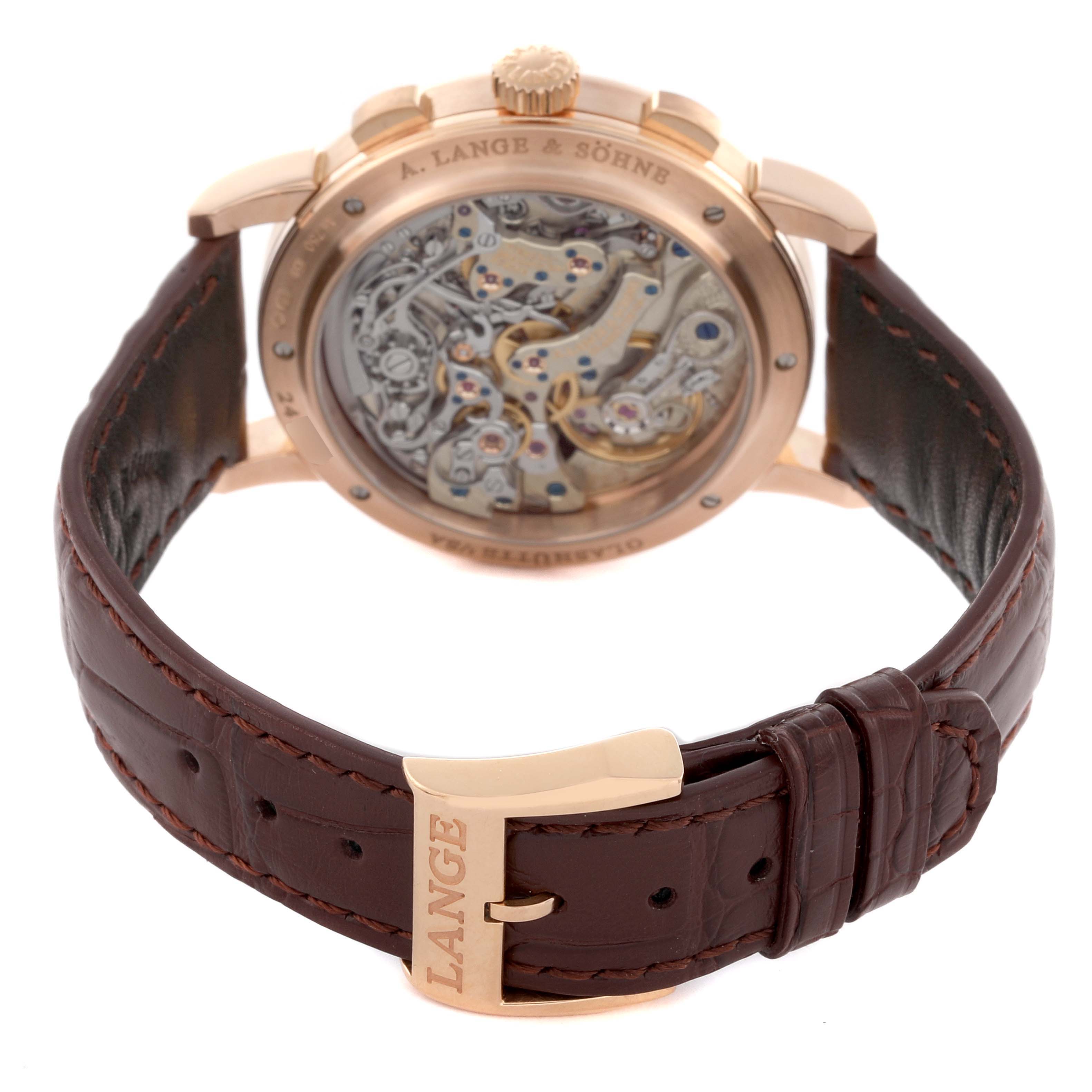The A. Lange & Sohne 1815 414.032 Men's Rose Gold Silver Dial model is shown from the back, displaying its intricate movement and brown leather strap.