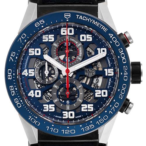 The Carrera model by Tag Heuer is shown from a front angle, featuring the dial and tachymeter bezel.