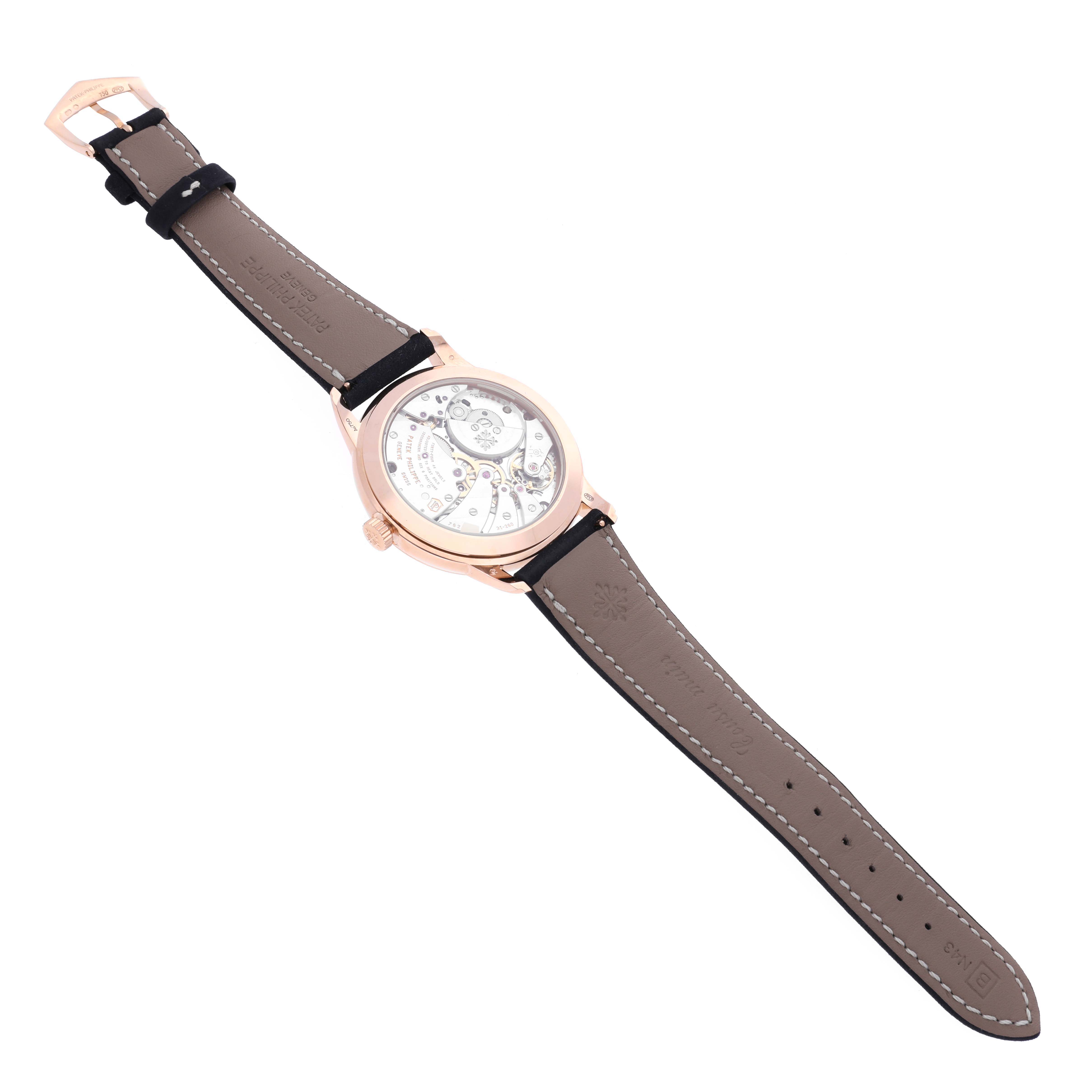 The Patek Philippe Calatrava 5224R-001 Men's Rose Gold Blue Dial 5224R-001 Men's Rose Gold Blue Dial watch is shown from a rear angle, highlighting its transparent case back and leather strap.