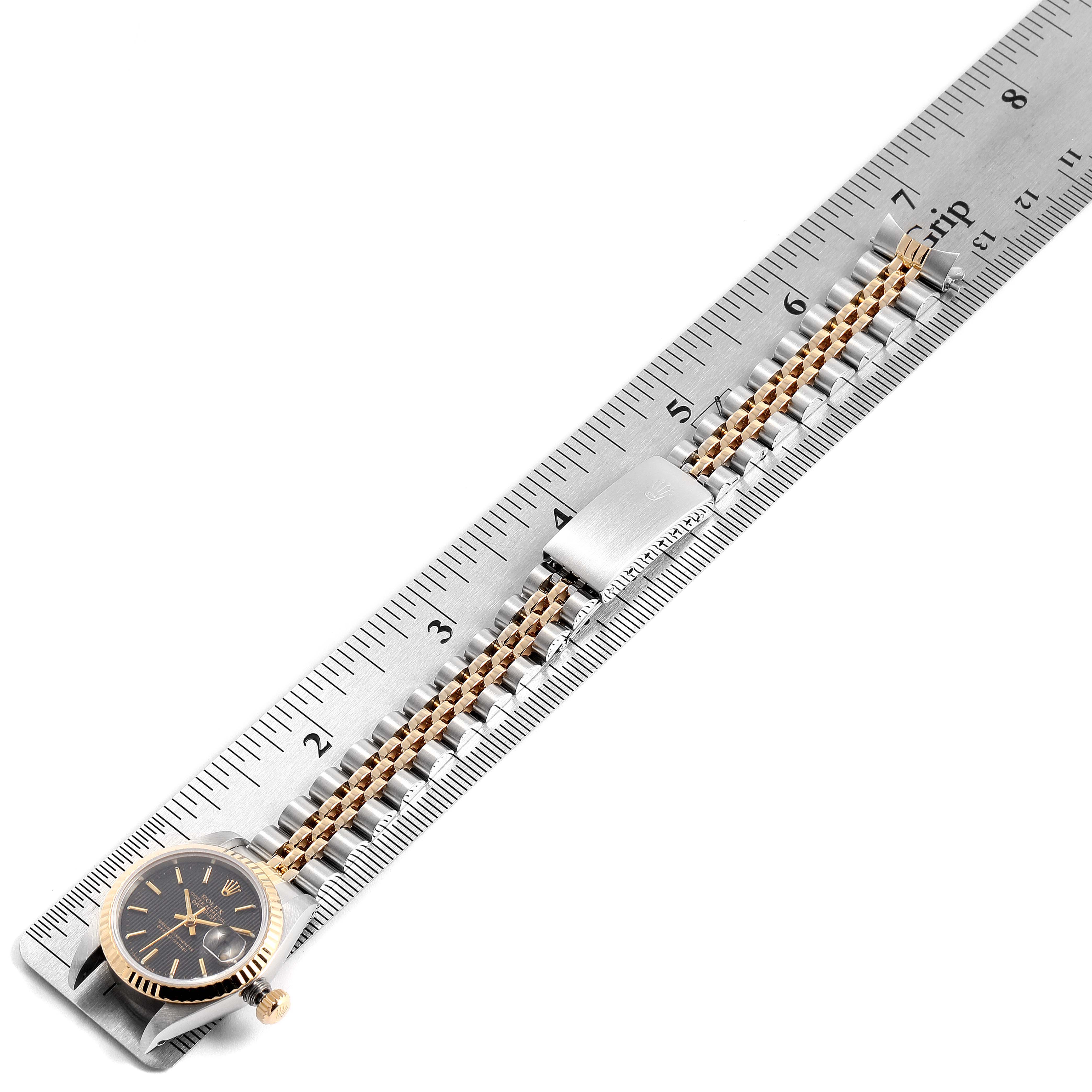 The image shows the face and bracelet of a Rolex Datejust 69173 Women's Steel and Gold (two tone) Black Dial 69173 Women's Steel and Gold (two tone) Black Dial watch placed alongside a ruler for size reference.