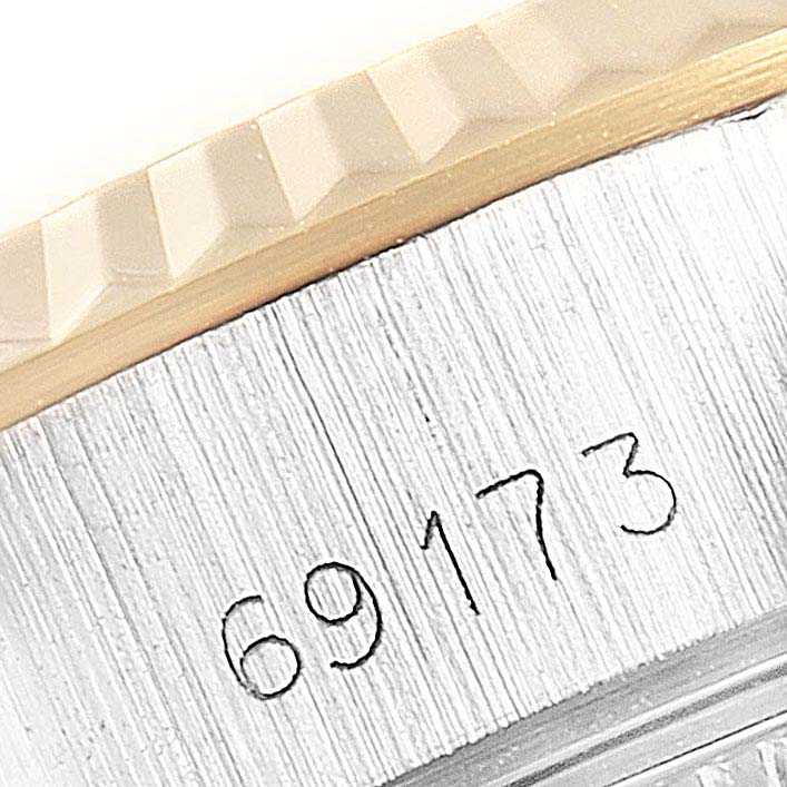 The image shows a close-up of the serial number and part of the textured bezel of a Rolex Datejust 69173 Women's Steel and Gold (two tone) Black Dial 69173 Women's Steel and Gold (two tone) Black Dial watch.