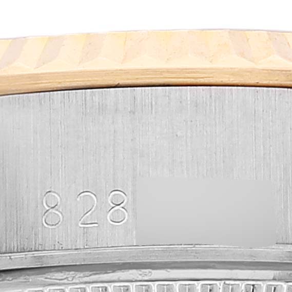 This close-up image of a Rolex Date 69173 Women's Steel and Gold (two tone) White Dial 69173 Women's Steel and Gold (two tone) White Dial model watch shows the side casing with engraved serial numbers.