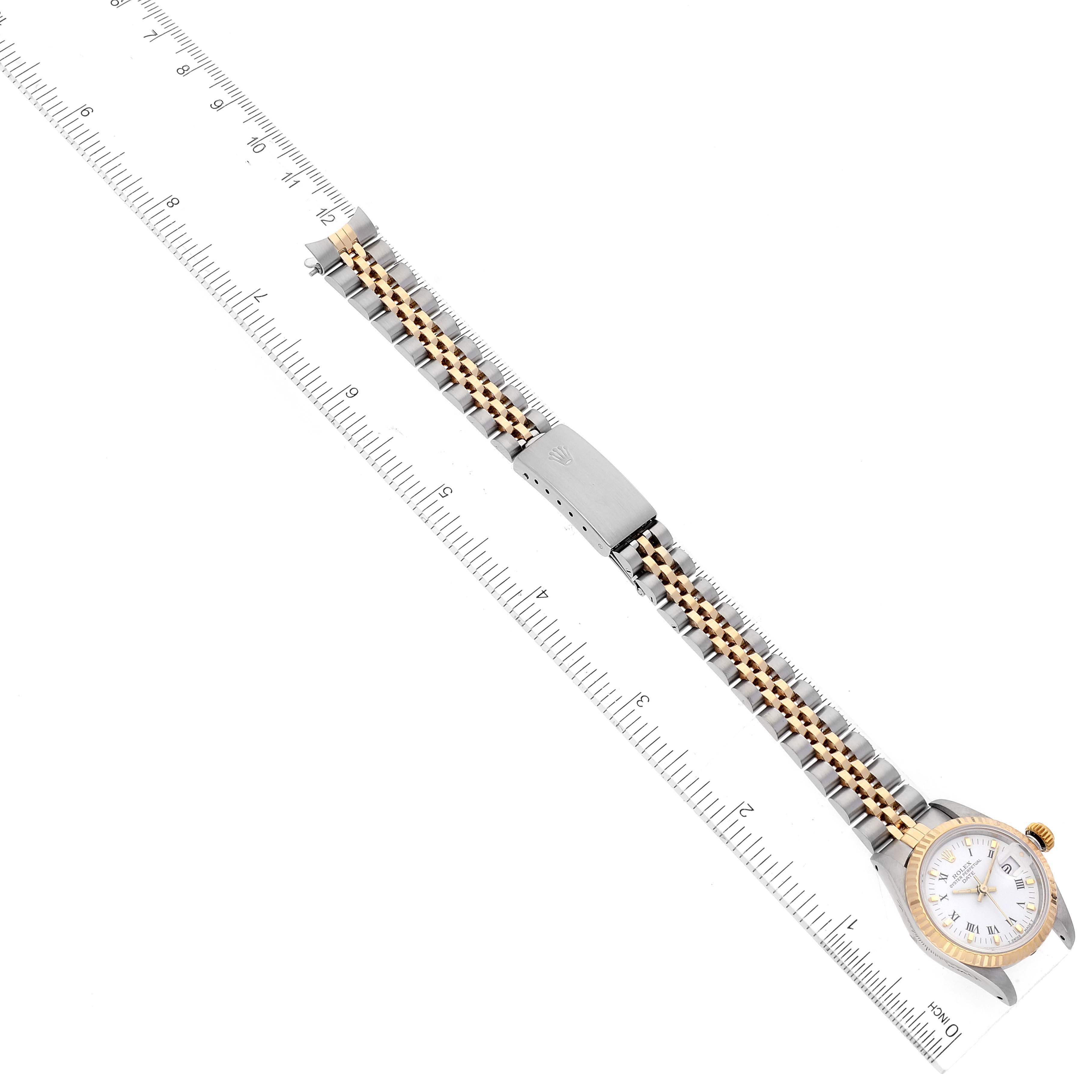 The image shows a Rolex Date 69173 Women's Steel and Gold (two tone) White Dial 69173 Women's Steel and Gold (two tone) White Dial watch laid flat with its face visible and bracelet extended alongside a ruler.