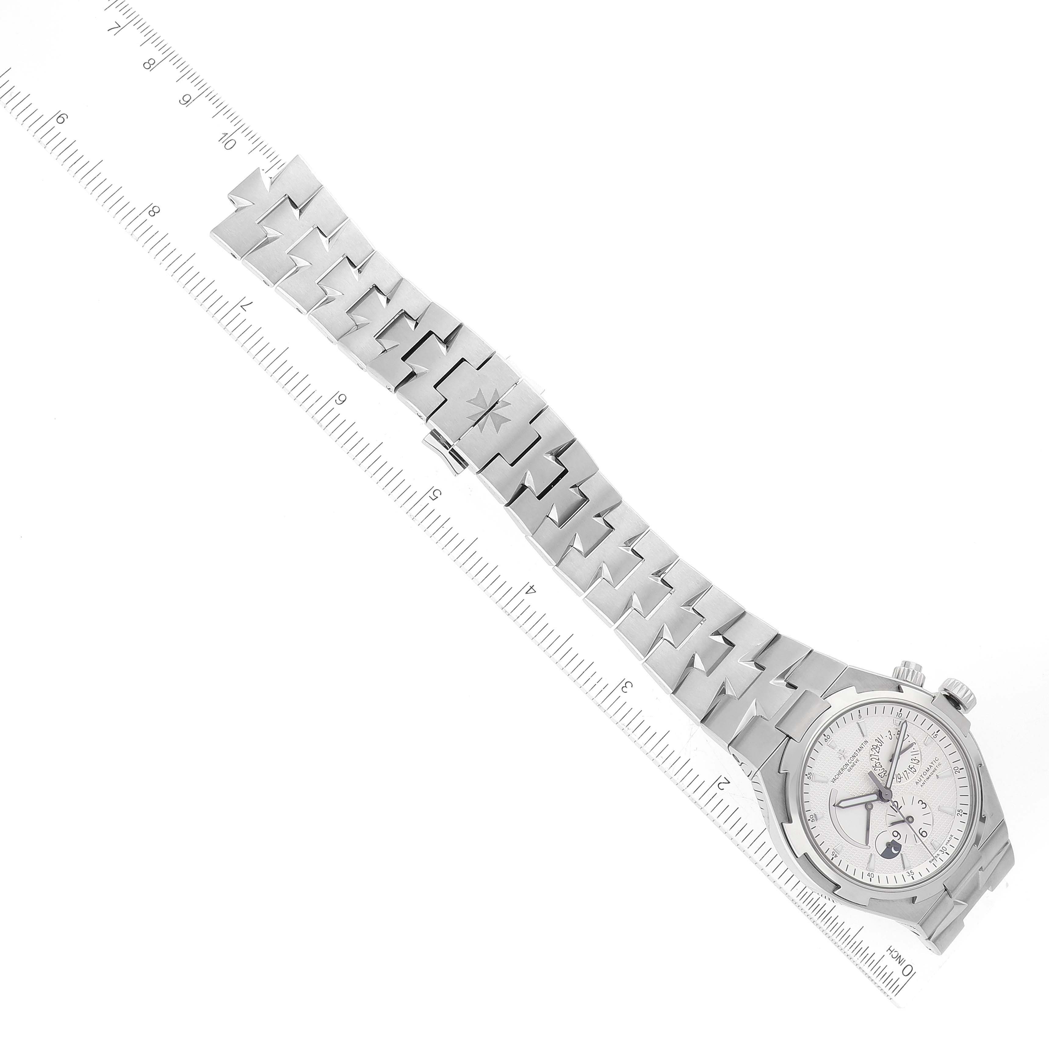 The image shows a Vacheron Constantin Overseas 47450/B01A-9226 Men's Stainless Steel Silver Dial 47450/B01A-9226 Men's Stainless Steel Silver Dial watch in a flat view, displaying its dial and metal bracelet alongside a ruler for scale.