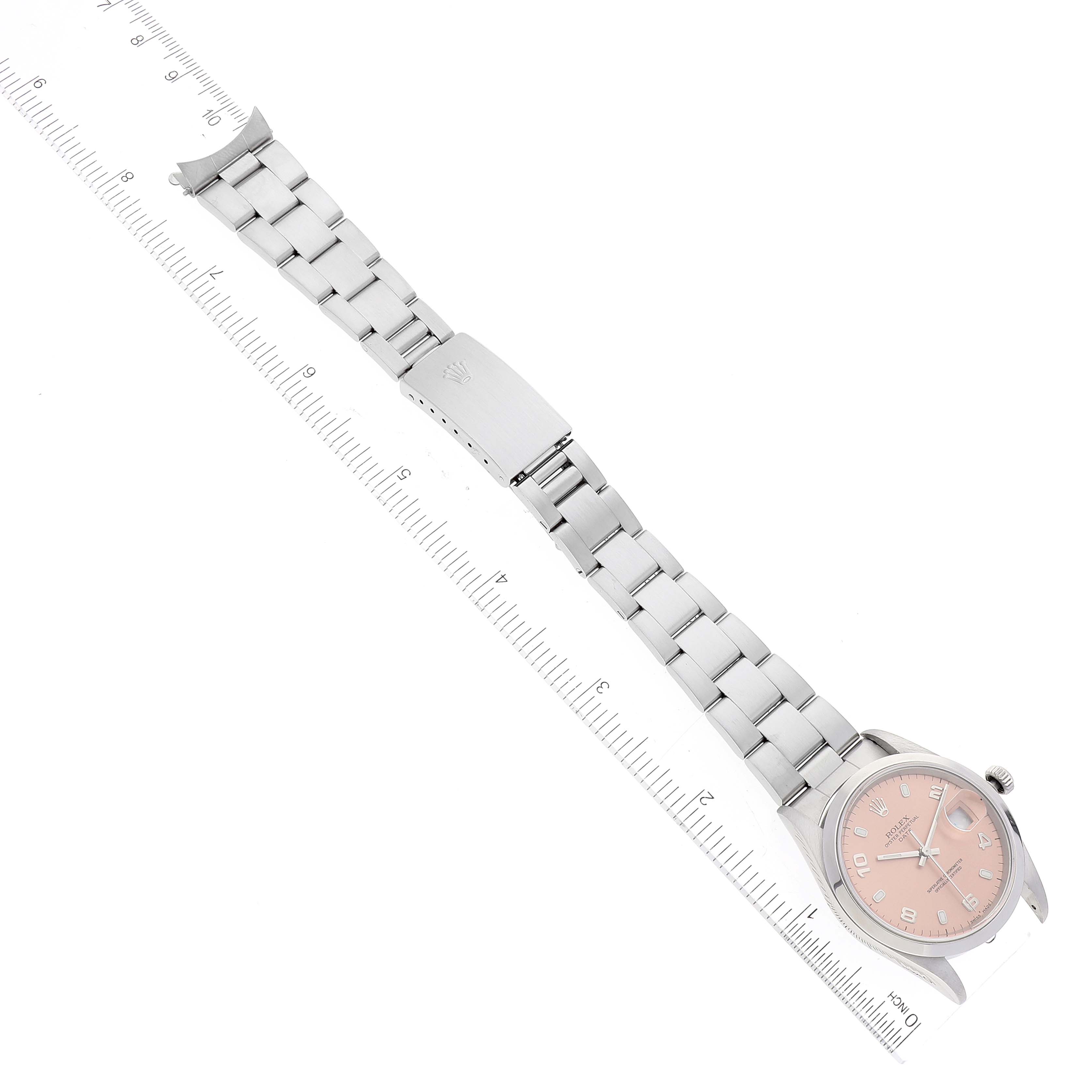 The Rolex Date 15200 Men's Stainless Steel Pink Dial 15200 Men's Stainless Steel Pink Dial model watch is shown from an overhead angle, displaying the bracelet, clasp, case, and dial with rulers beside it.