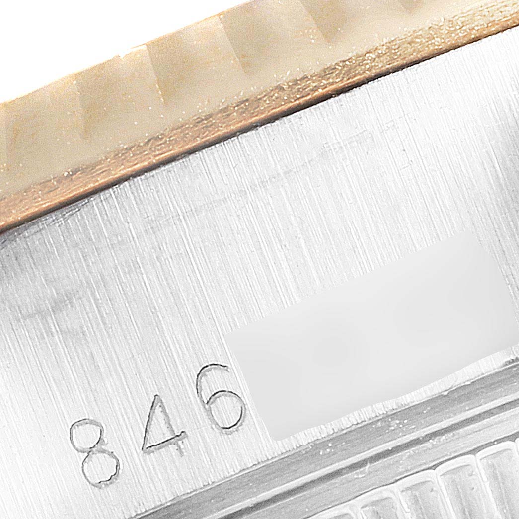 This close-up image of the Rolex Datejust 69173 Women's Steel and Gold (two tone) Silver Dial 69173 Women's Steel and Gold (two tone) Silver Dial watch shows part of the bezel and the serial number engraving.