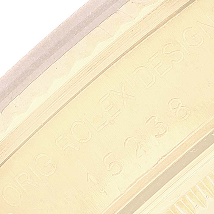 This image shows an angled close-up of the engraved edge of a Rolex Date 15238 Men's Yellow Gold White Dial 15238 Men's Yellow Gold White Dial model, displaying the serial and model numbers.