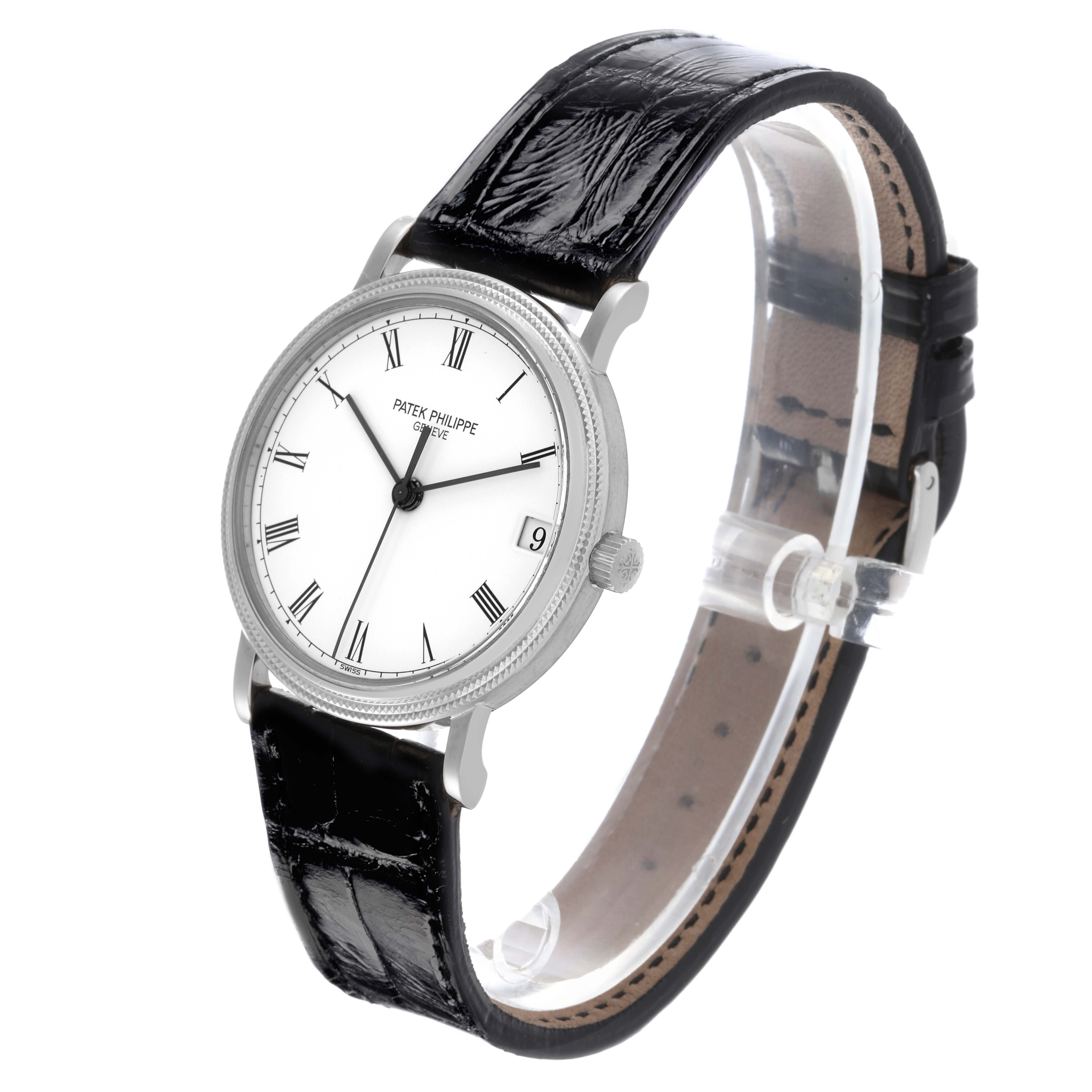 The Patek Philippe Calatrava 3802/200G-001 Men's White Gold White Dial 3802/200G-001 Men's White Gold White Dial watch is shown at an oblique angle, highlighting its face, black strap, case, and crown.