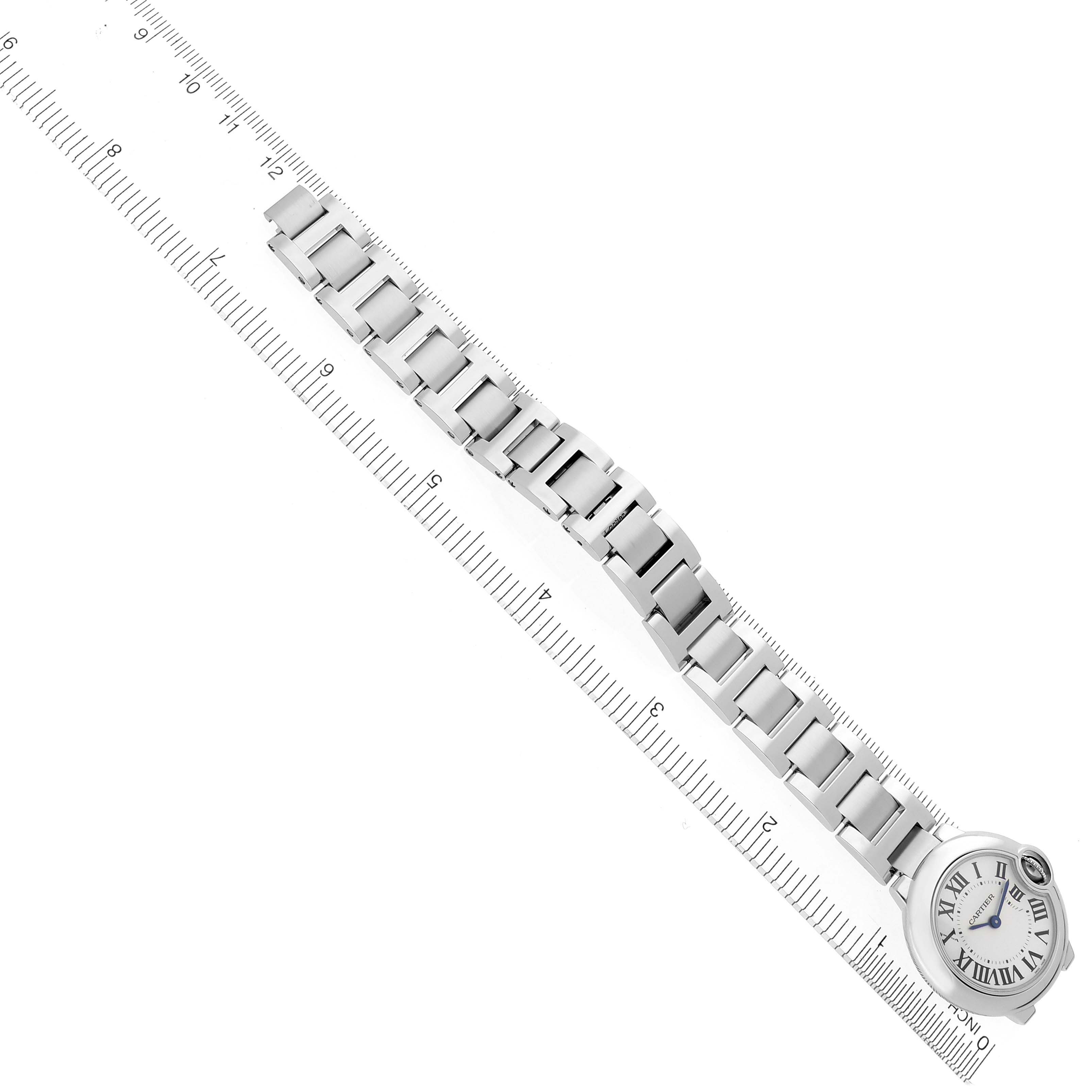 The Cartier Ballon Bleu W69010Z4 Women's Stainless Steel Silver Dial W69010Z4 Women's Stainless Steel Silver Dial watch is shown from a top view with a focus on its bracelet and face beside a ruler.