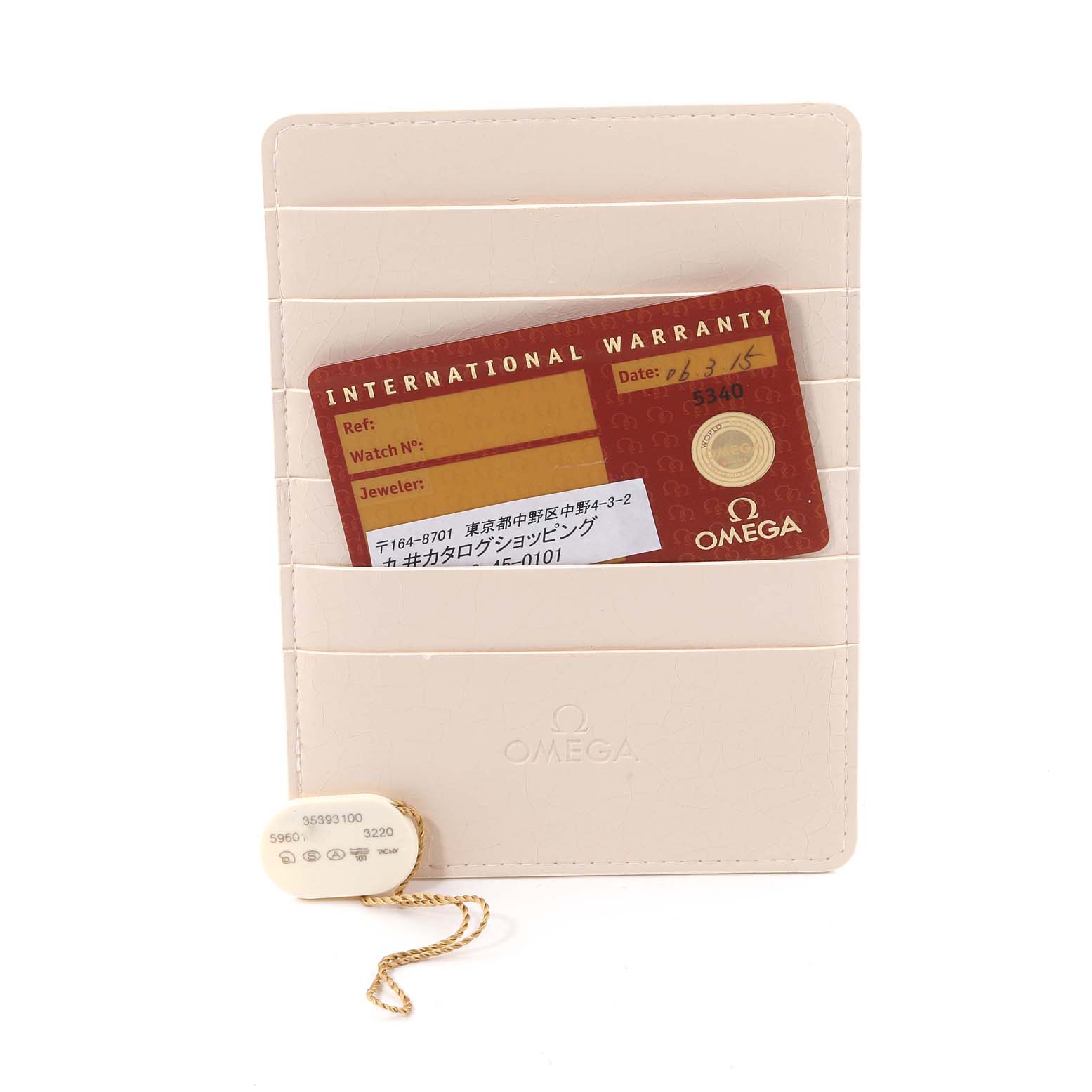 The image shows an Omega Speedmaster 3539.31.00 Men's Stainless Steel Silver Dial 3539.31.00 Men's Stainless Steel Silver Dial International Warranty card in a cream cardholder, along with an Omega tag on a chain.