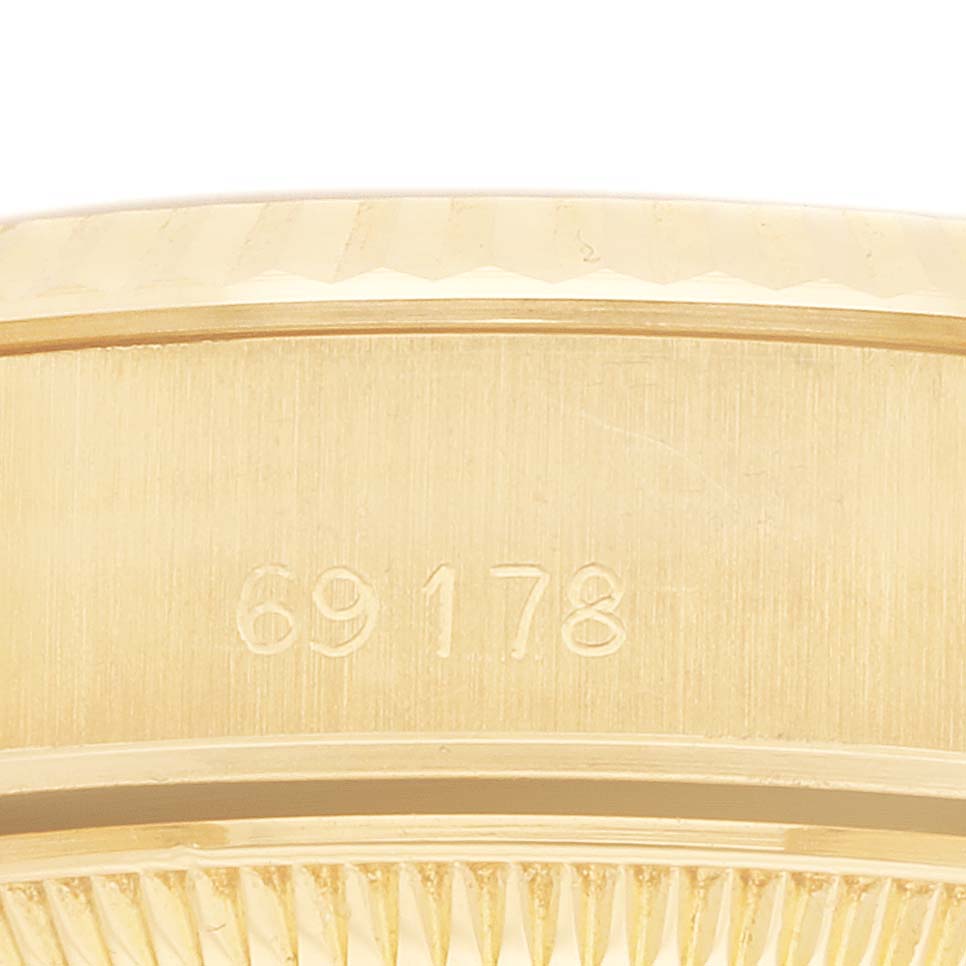 The image shows a close-up side view of the Rolex Datejust 69178 Women's Yellow Gold White Dial model, highlighting the engraved model number and fluted bezel.
