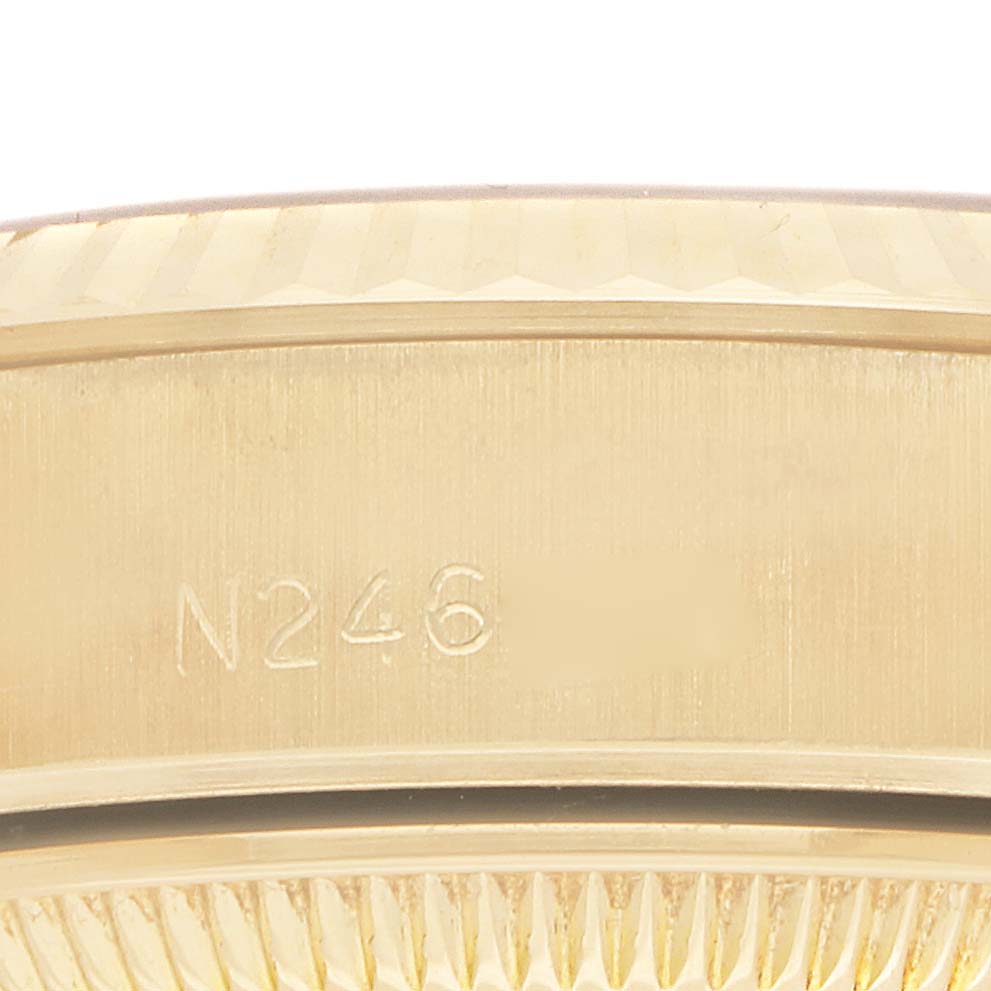The image shows a close-up of the side of a Rolex Datejust 69178 Women's Yellow Gold White Dial watch, focusing on the bezel with an engraved number.