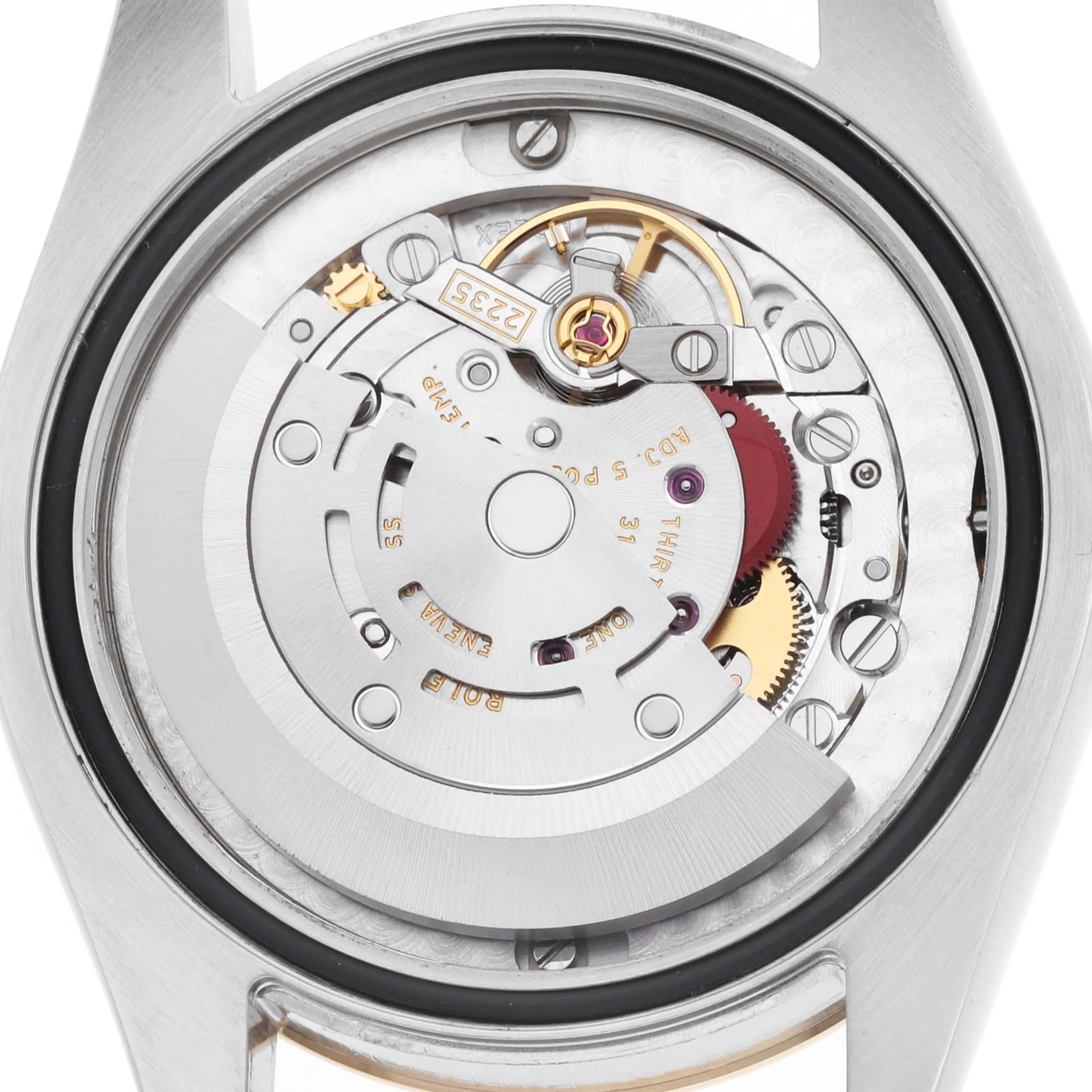 The image shows the movement of a mid-size Rolex watch from the back, revealing gears and the rotor.