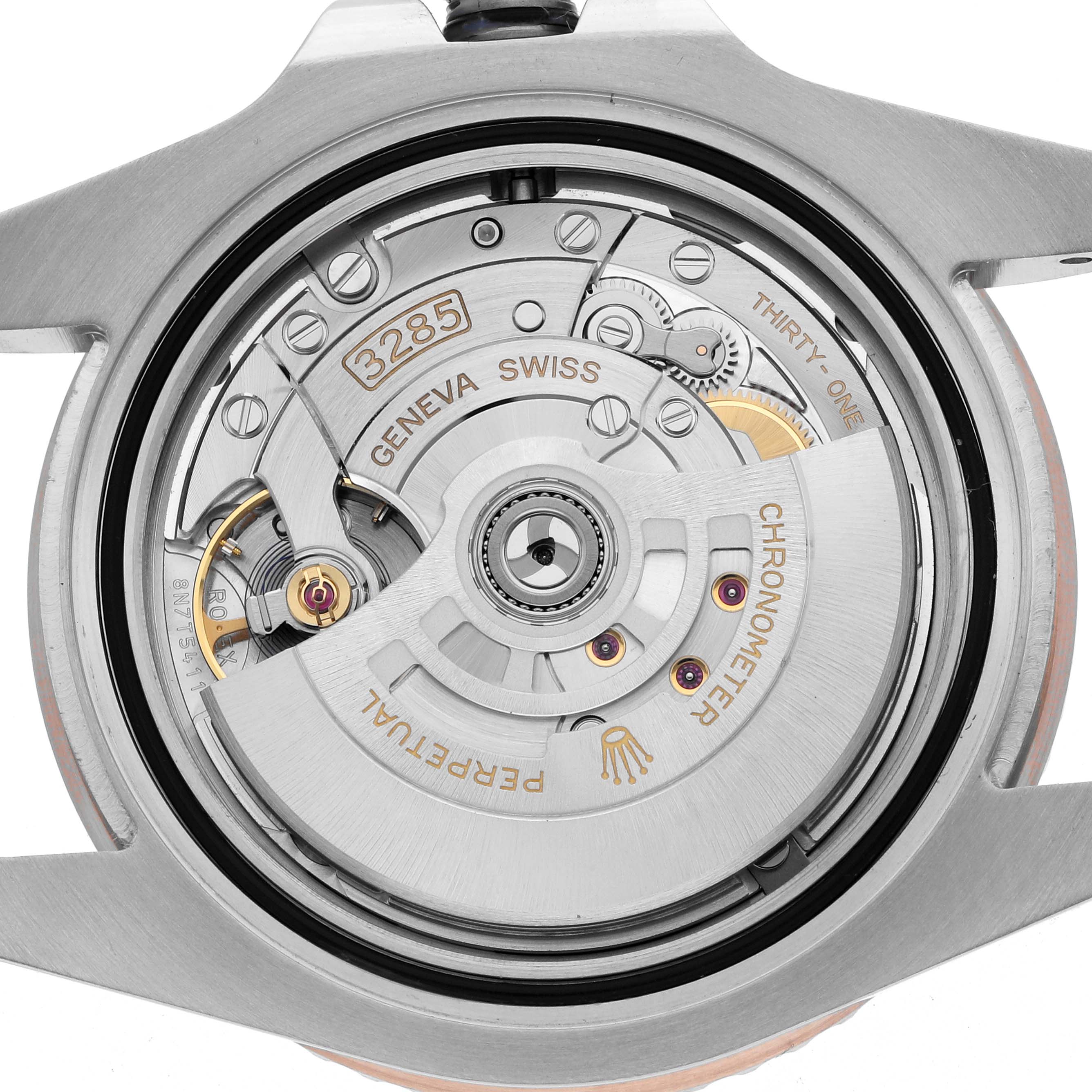 The image shows the back view of a Rolex GMT-Master 126711 Men's Steel and Gold (two tone) Black Dial watch, focusing on its intricate movement and components.