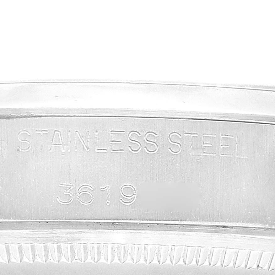 The image shows a close-up of the case side of a Rolex Date 1500 Men's Stainless Steel Silver Dial 1500 Men's Stainless Steel Silver Dial model, highlighting the "STAINLESS STEEL" engraving with part of the serial number.