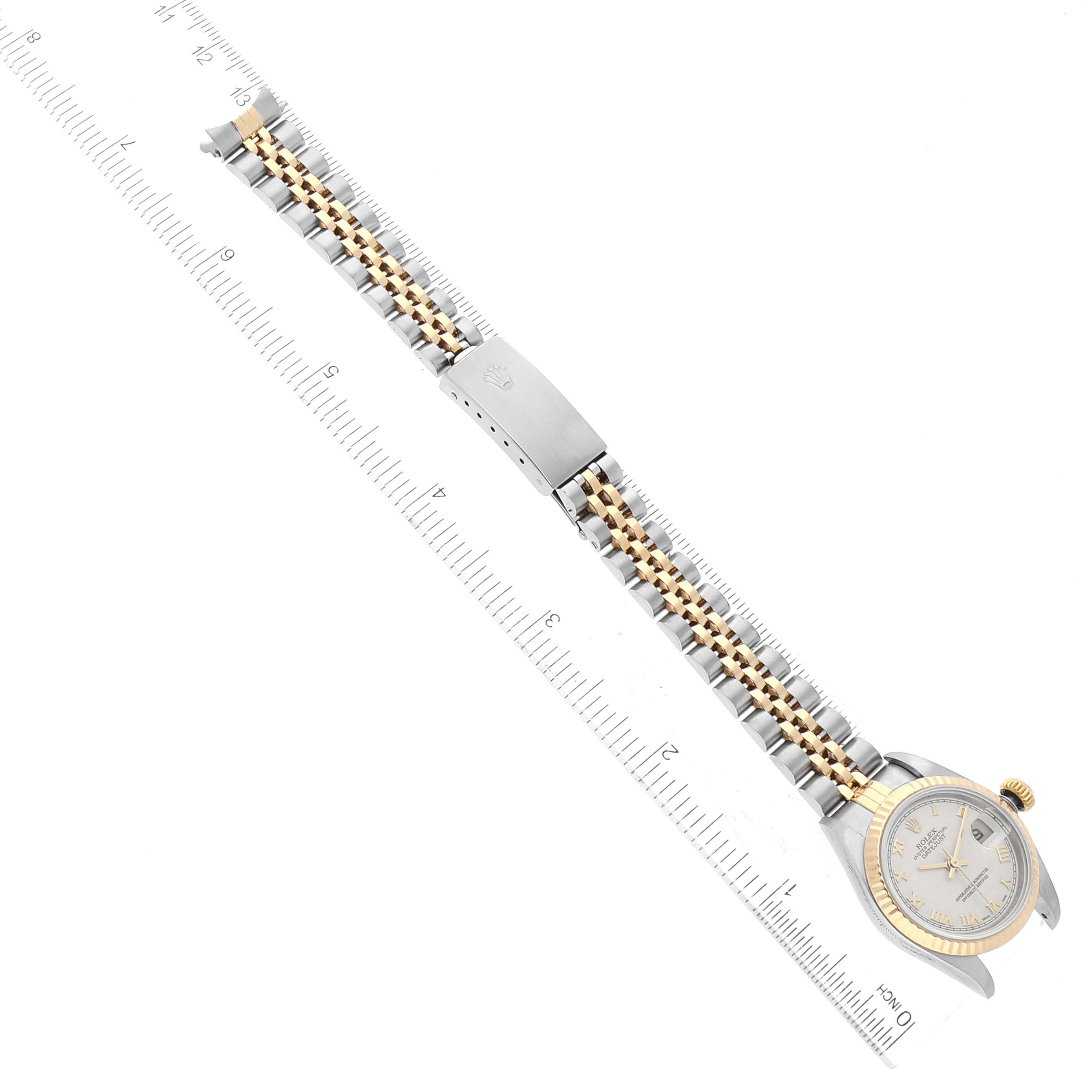 The Rolex Datejust 79173 Women's Steel and Gold (two tone) Beige Dial 79173 Women's Steel and Gold (two tone) Beige Dial watch is shown flat from above, alongside a ruler, displaying its face, bezel, and entire bracelet.