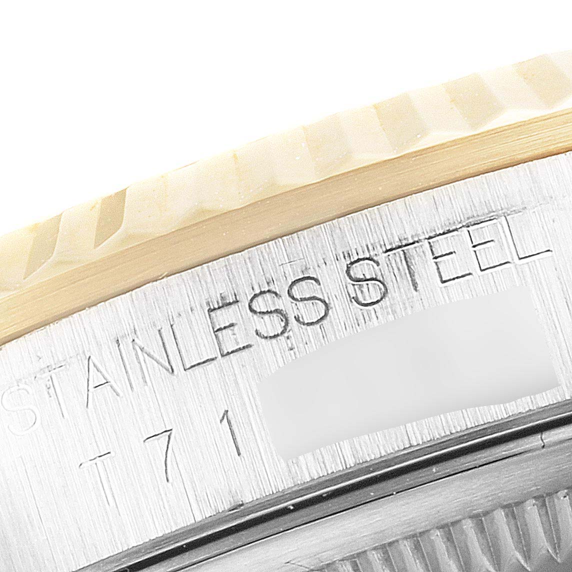 The image shows a close-up of the engraving on the side of the bezel of a Rolex Datejust 16233 Men's Steel and Gold (two tone) Mother of Pearl Dial 16233 Men's Steel and Gold (two tone) Mother of Pearl Dial watch.