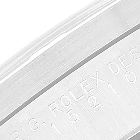 This close-up image shows the edge of a Rolex Date 15210 Men's Stainless Steel Blue Dial 15210 Men's Stainless Steel Blue Dial model, showcasing part of the engraved lettering.