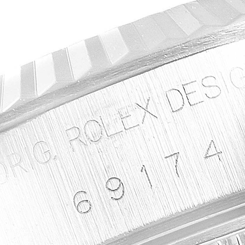 The image shows a close-up side view of the case and fluted bezel of a Rolex Datejust 69174 Women's Stainless Steel Pink Dial 69174 Women's Stainless Steel Pink Dial, revealing the model number and "Rolex Design" engraving.