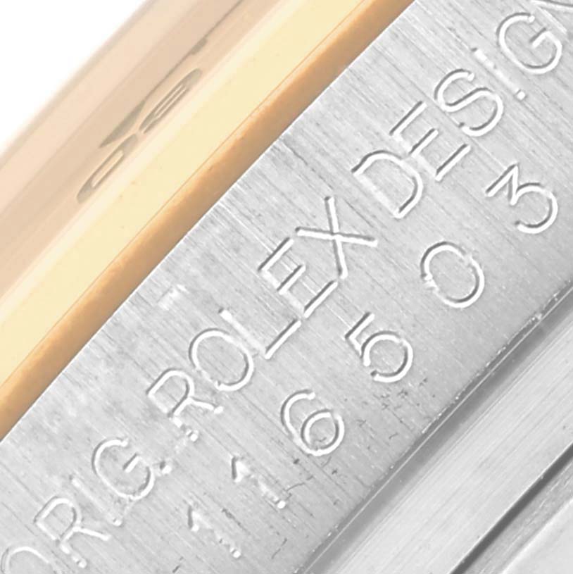 The image shows a close-up of the engraved bezel on a Rolex Daytona 116503 Men's Steel and Gold (two tone) Black Dial 116503 Men's Steel and Gold (two tone) Black Dial.