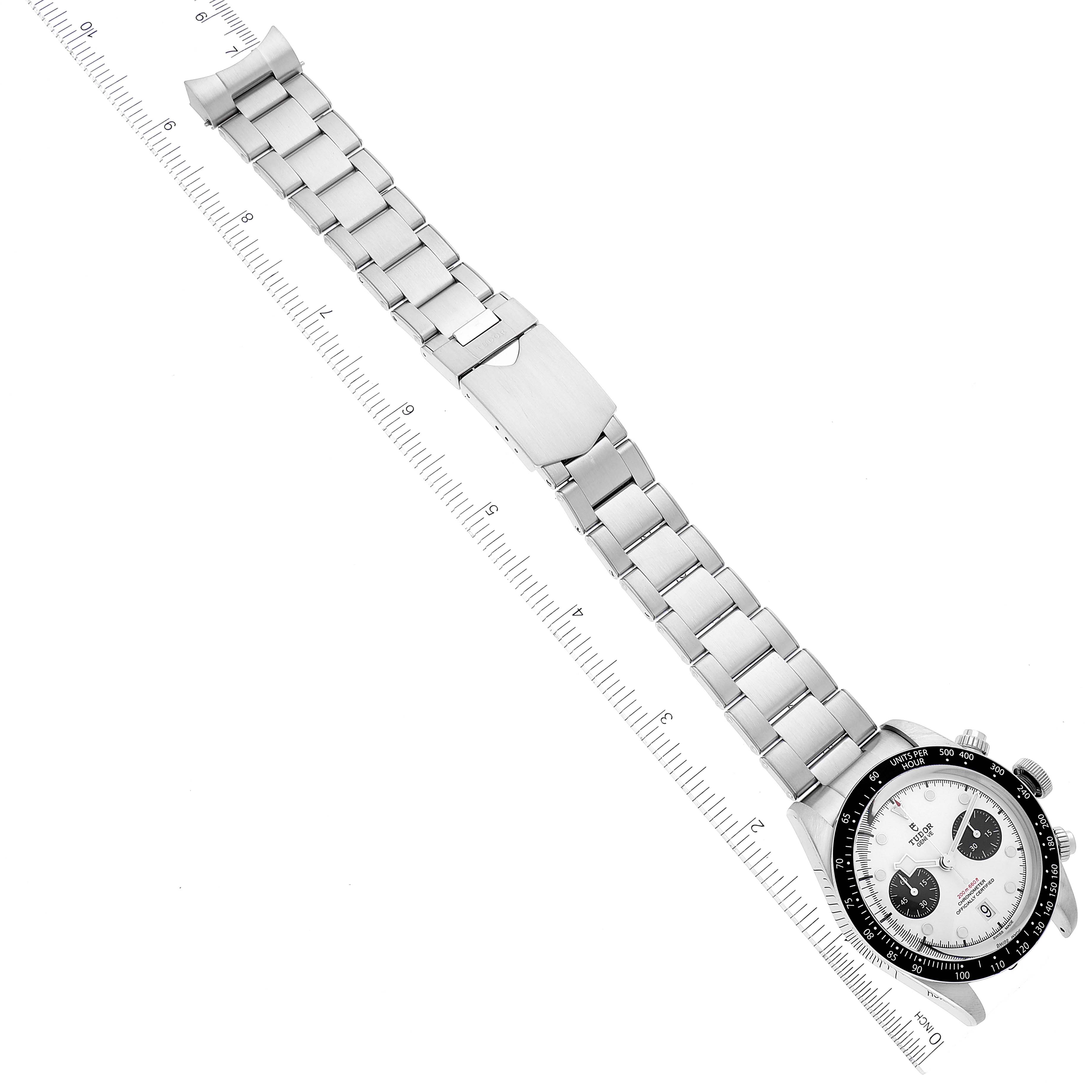 The image shows a Tudor Heritage Black Bay 79360N Men's Stainless Steel White Dial 79360N Men's Stainless Steel White Dial watch with a full view of its metal bracelet and clasp, positioned along a ruler.