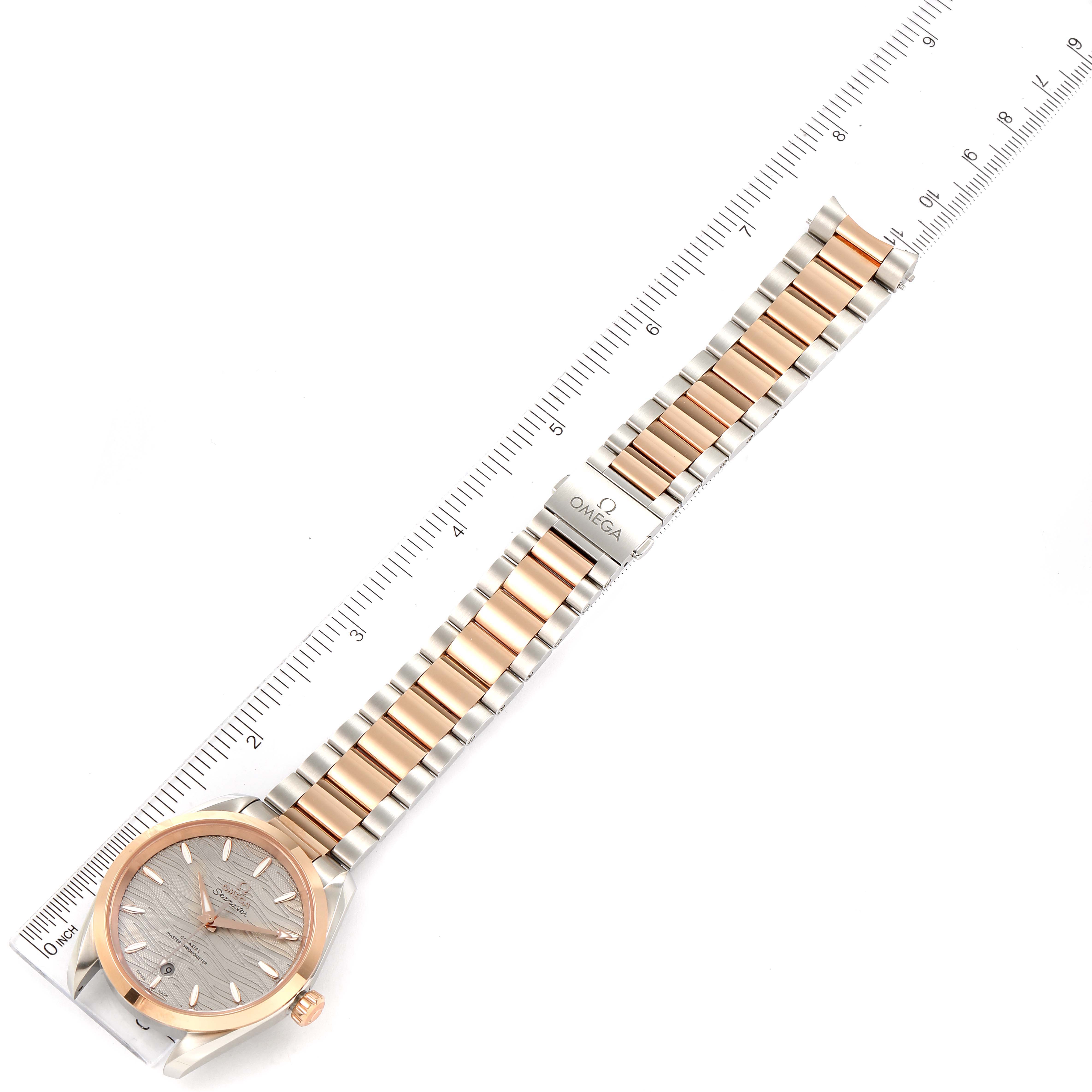 The Omega 220.20.38.20.06.001 Women's Steel and Gold (two tone) Grey Dial 220.20.38.20.06.001 Women's Steel and Gold (two tone) Grey Dial Seamaster Aqua Terra Steel Rose Gold Watch 220.20.38.20.06.001 is displayed flat, showing its bracelet and face with a ruler for scale.