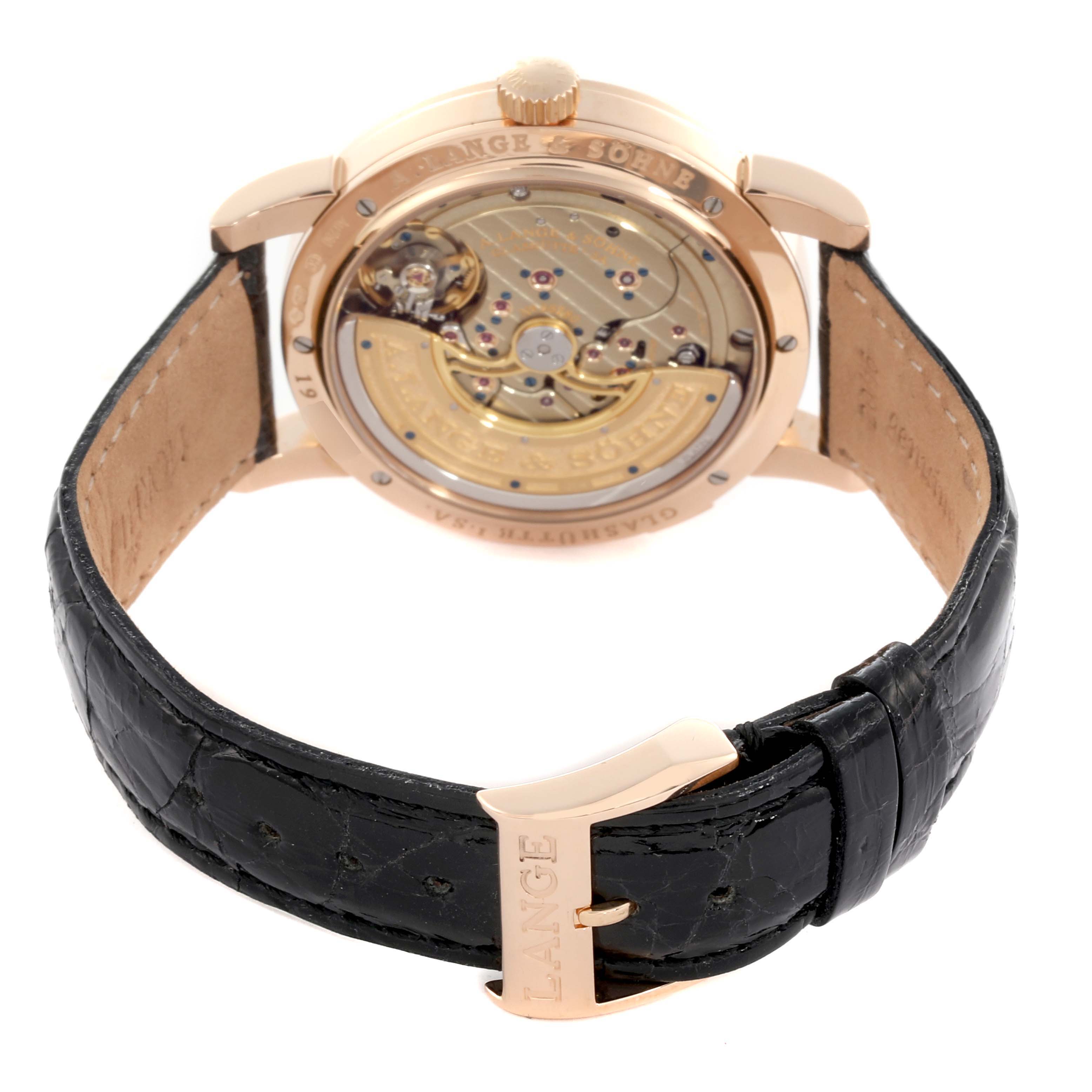 The image shows the back view of an A. Lange & Sohne Lange 1 320.032 Men's Rose Gold Silver Dial watch, highlighting its movement and leather strap.