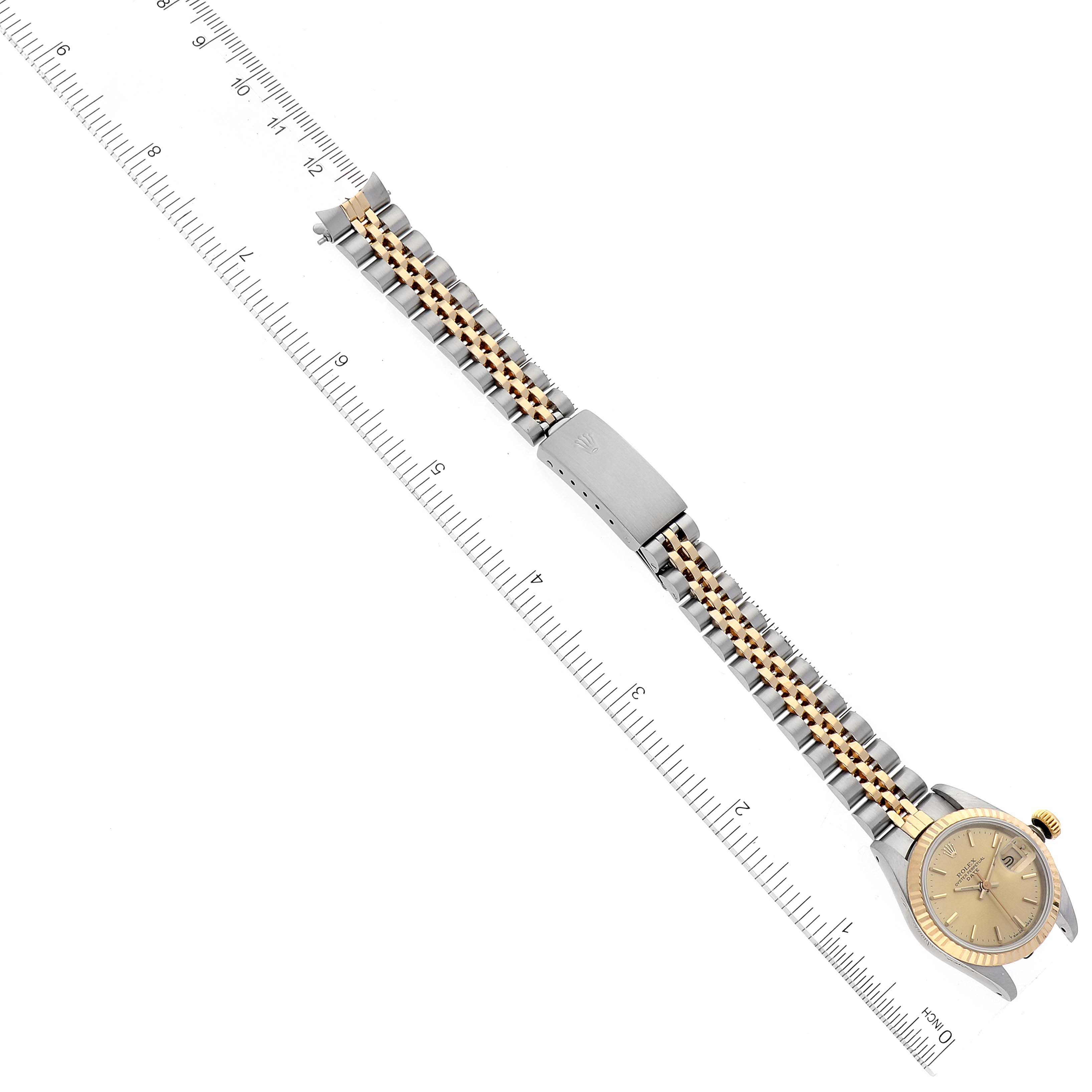 The Rolex Datejust 69173 Women's Steel and Gold (two tone) Champagne Dial 69173 Women's Steel and Gold (two tone) Champagne Dial watch is shown at a slight angle, displaying the full band and the watch face alongside a ruler.