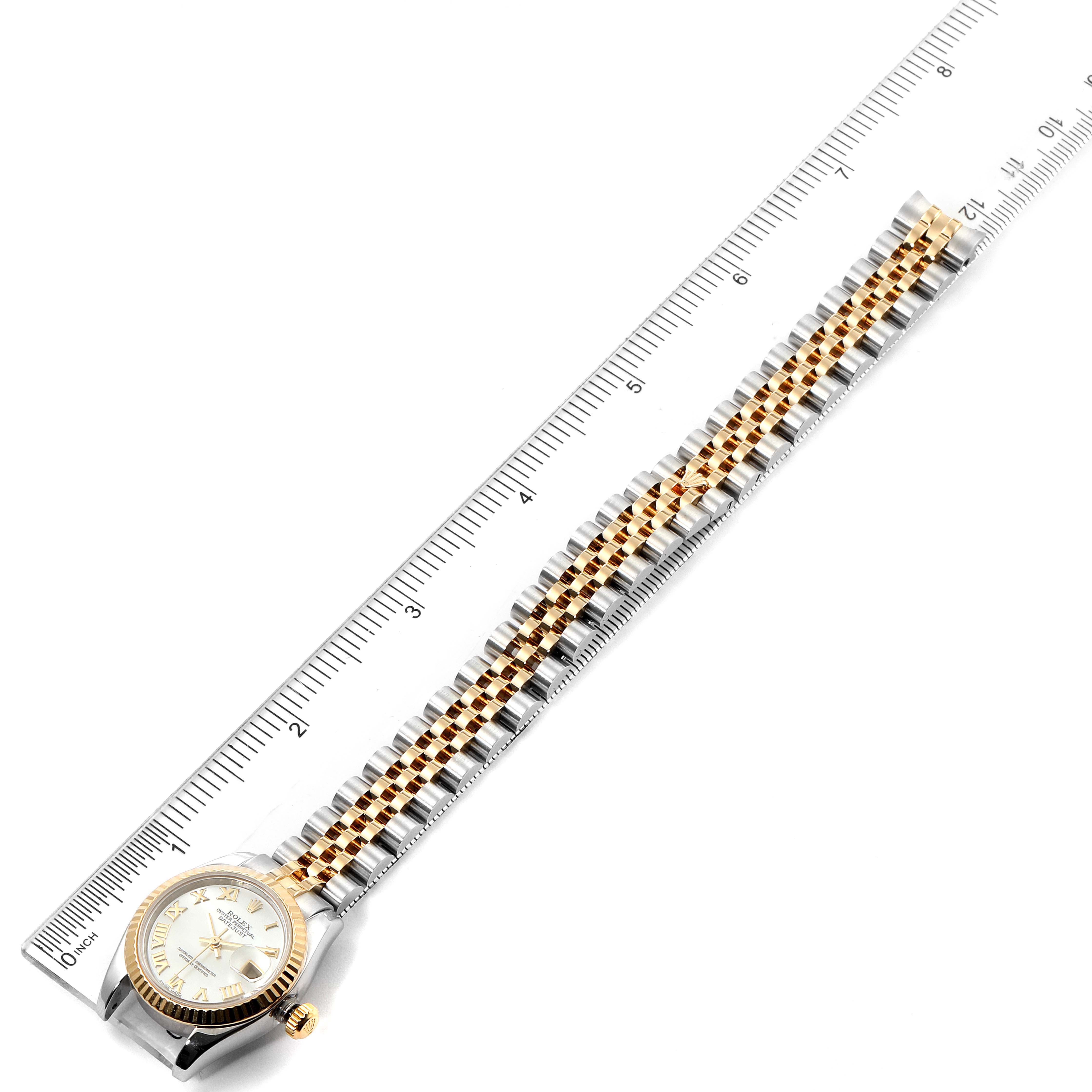 This image shows a Rolex Datejust 179173 Women's Steel and Gold (two tone) Mother of Pearl Dial 179173 Women's Steel and Gold (two tone) Mother of Pearl Dial watch with a two-tone bracelet placed next to a ruler for measurement.