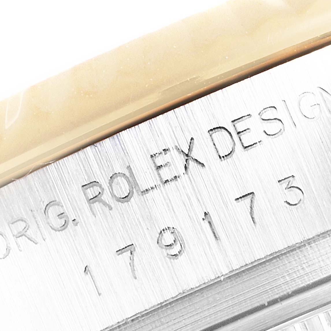 The image shows a close-up of the Rolex Datejust 179173 Women's Steel and Gold (two tone) Mother of Pearl Dial 179173 Women's Steel and Gold (two tone) Mother of Pearl Dial's case edge, highlighting the engraved model number and "Rolex Design" text.