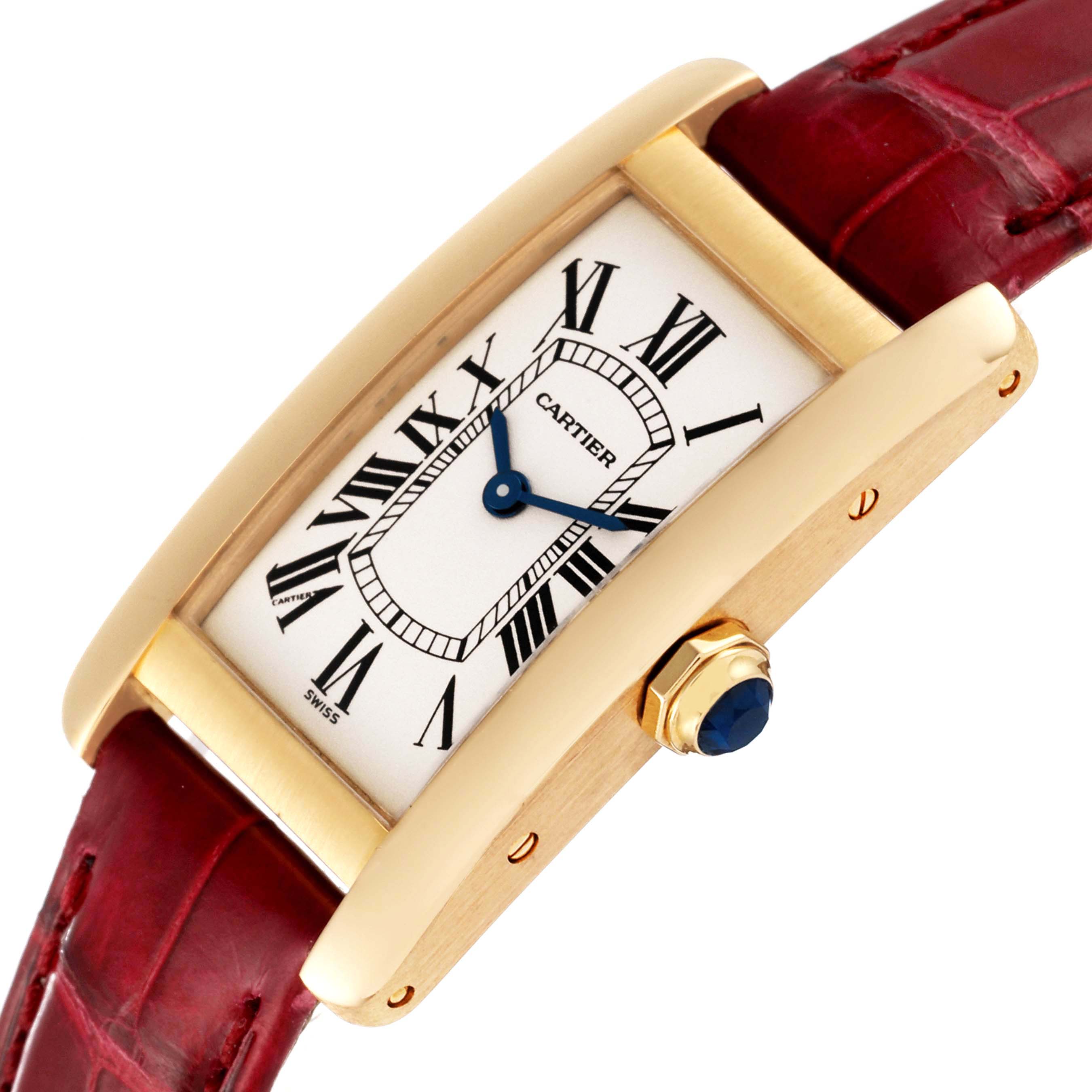 This image shows a Cartier Tank Americaine W2601556 Women's Yellow Gold Silver Dial W2601556 Women's Yellow Gold Silver Dial watch angled slightly from the side, displaying its dial, crown, and red leather strap.