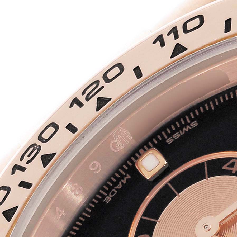The image shows a close-up of the Rolex Daytona 116505 Men's Rose Gold Black Dial 116505 Men's Rose Gold Black Dial's bezel and part of the dial.